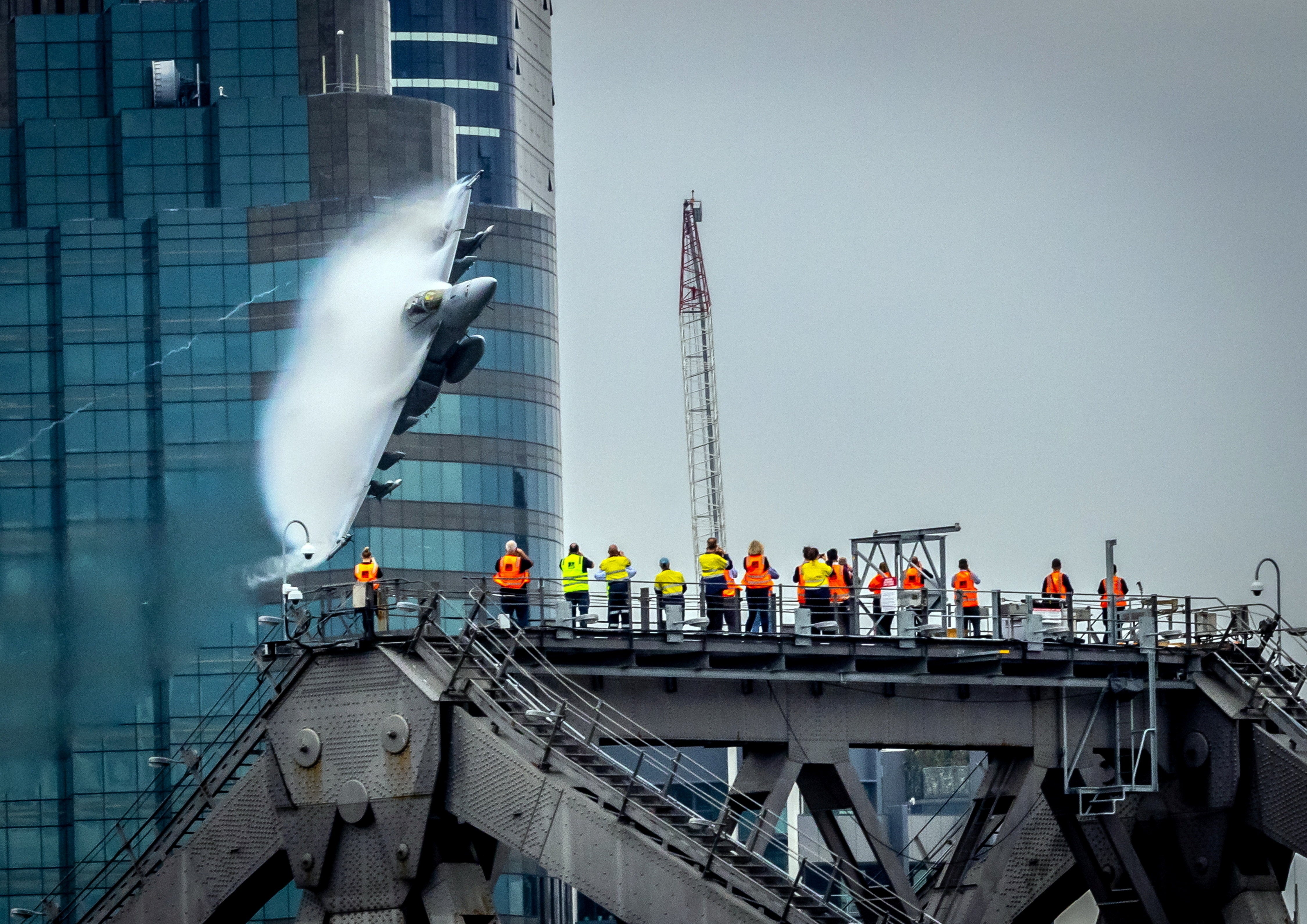 A fighter jet zooming at low level through a city