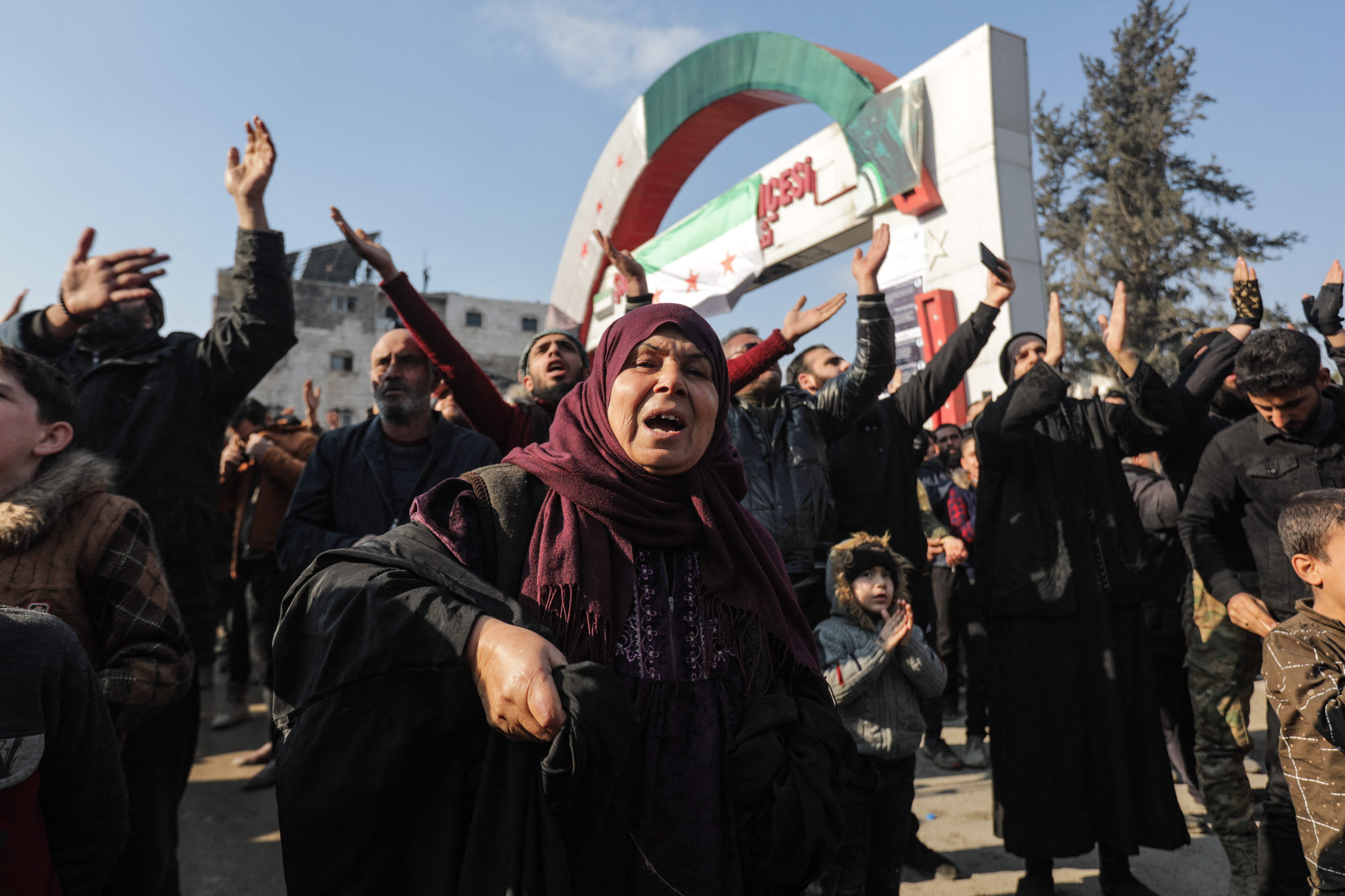 Demonstrators raise Syrian opposition flags and signs in a rally against talks in Moscow between Turkey and Assad’s regime in Syria