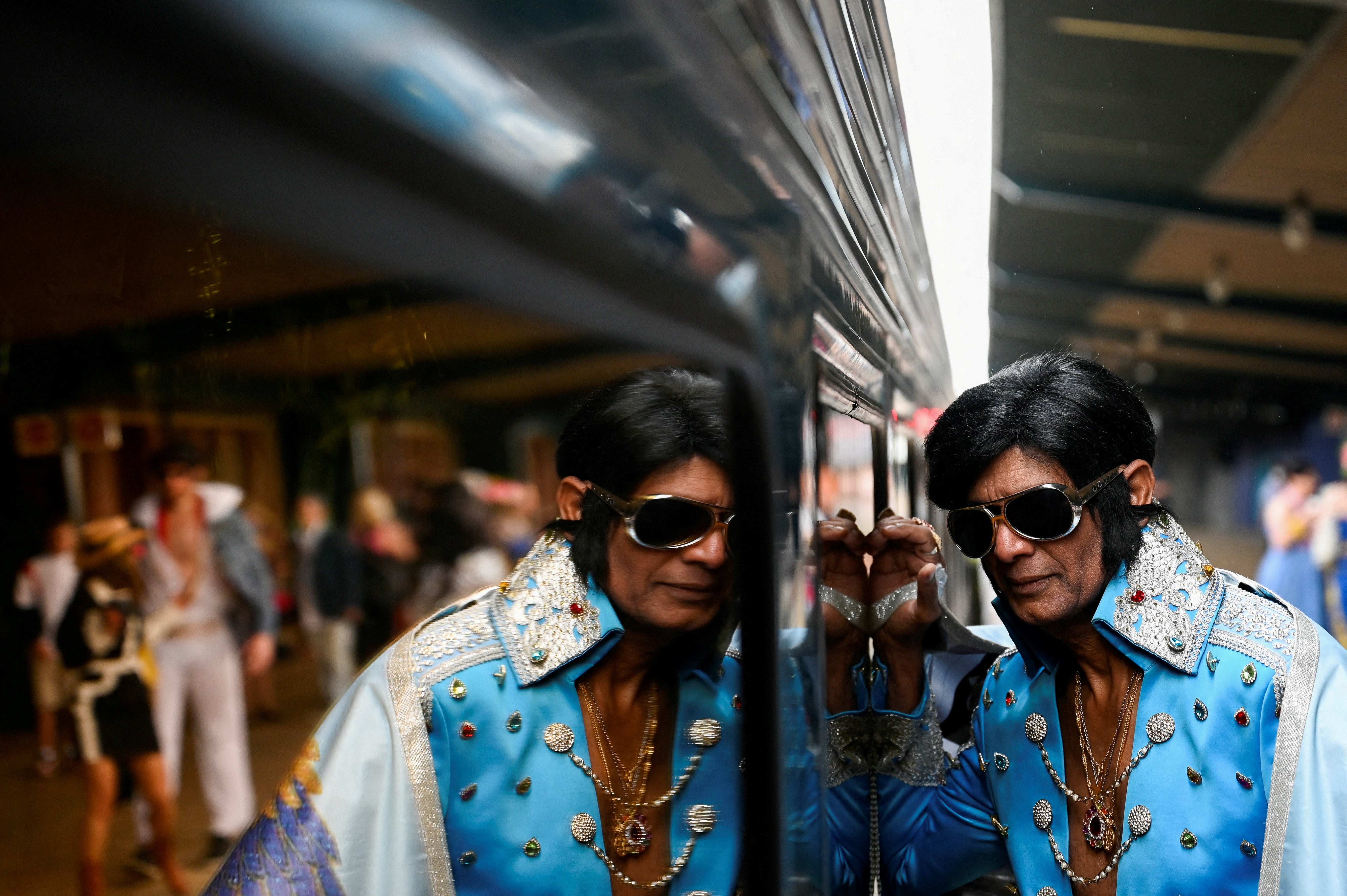 An Elvis Presley impersonator leans against the Elvis Express train at Sydney Central Railway Station before departing for the Parkes Elvis Festival