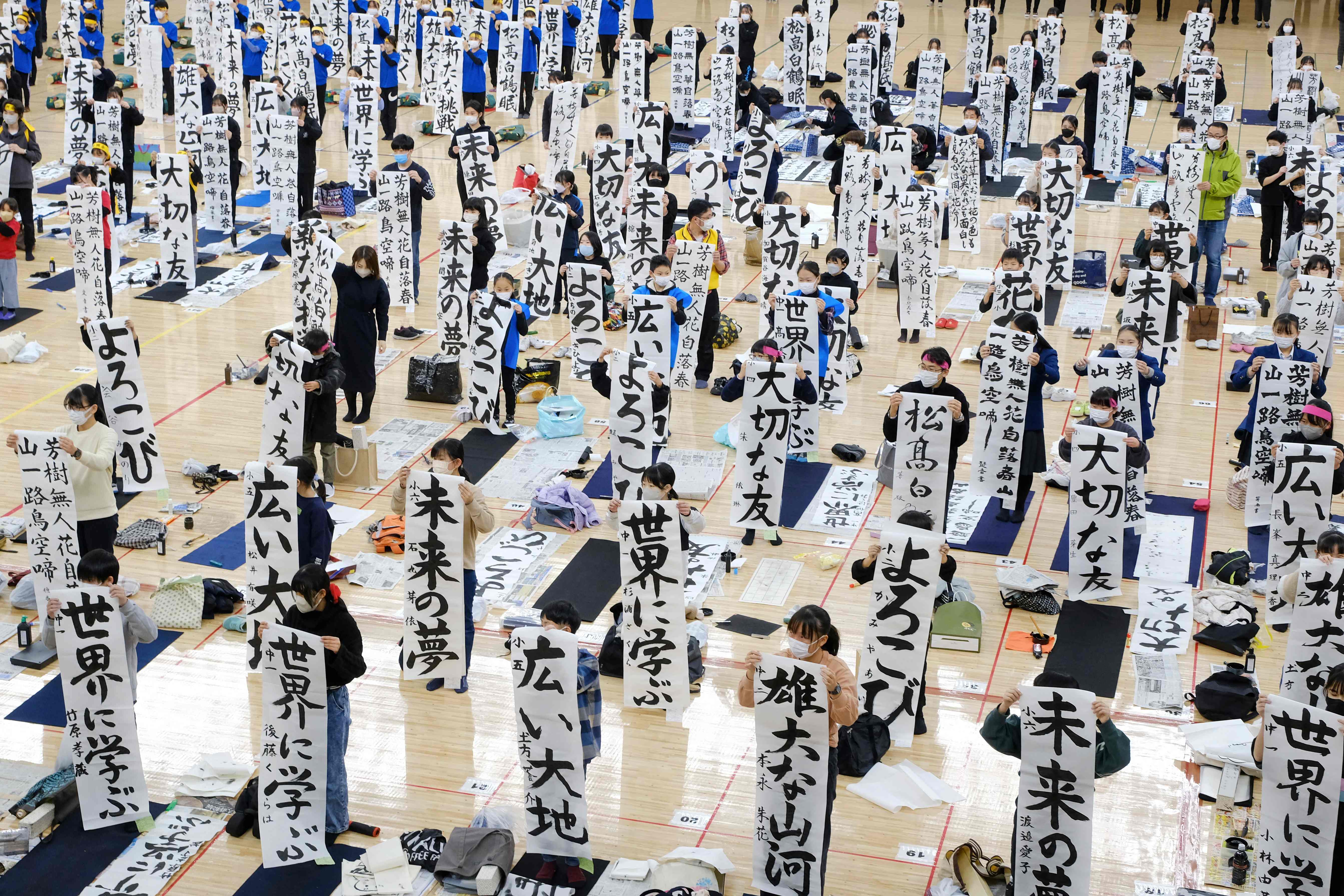 Participants show their work during the annual New Year calligraphy contest at Nippon Budokan hall in Tokyo