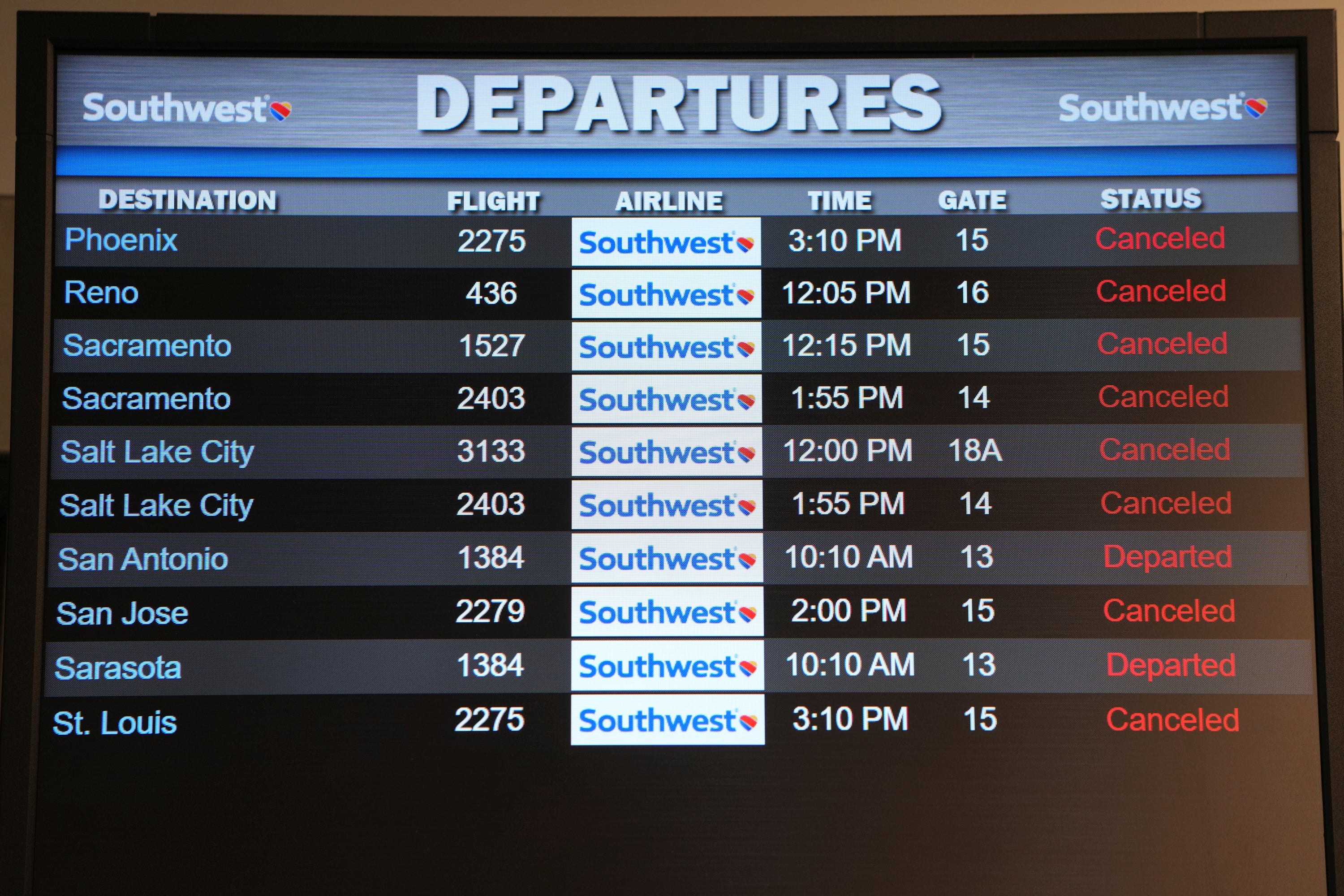 An airport monitor shows a string of Southwest cancellations over the holidays