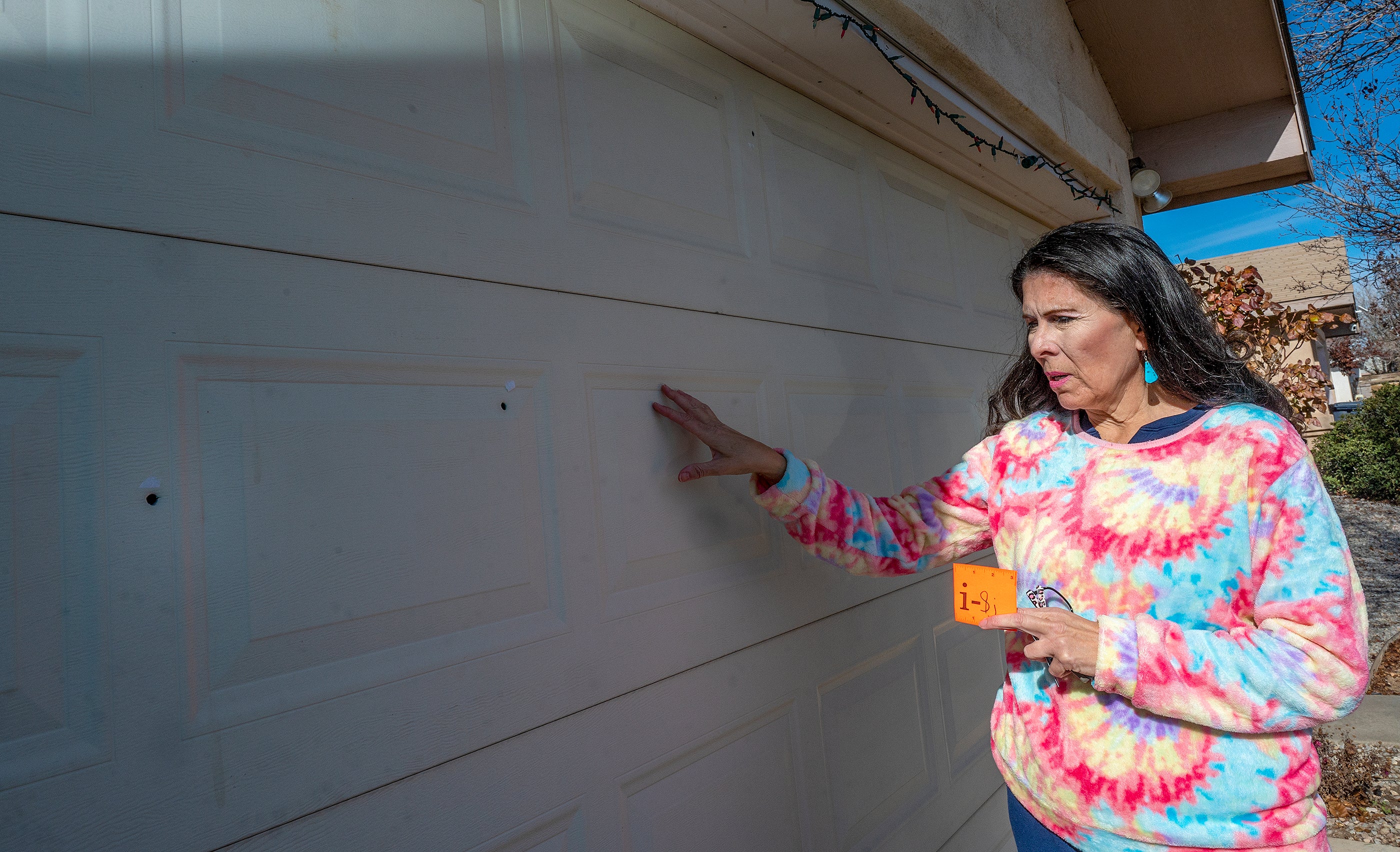 Sen. Linda Lopez , D-Albuquerque, shows bullet holes in her garage door after her home in Westside, Albuquerque, was shot in January