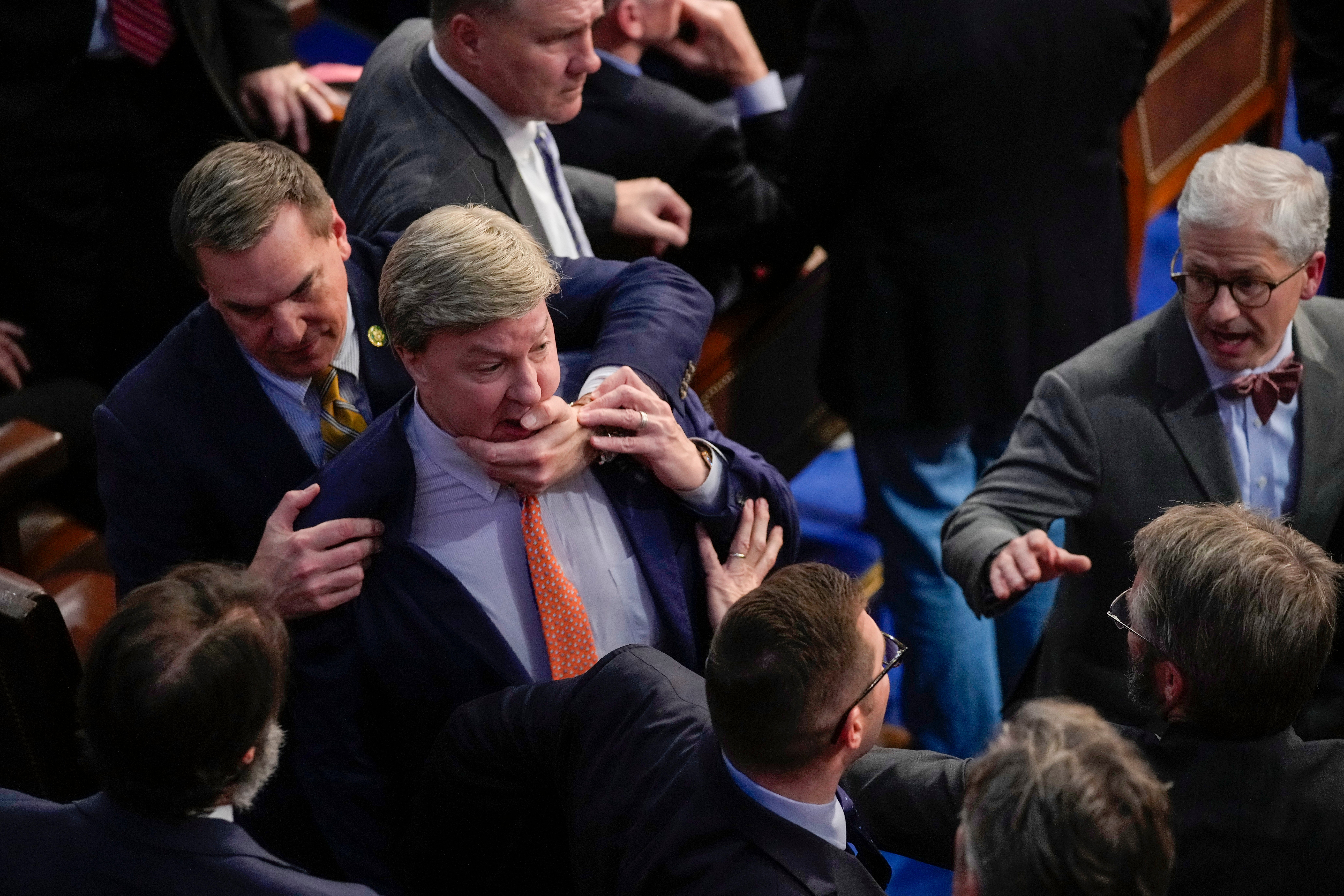 Richard Hudson, left, pulls Rep Mike Rogers back as he lunges at Matt Gaetz during the 14th round of voting for Speaker