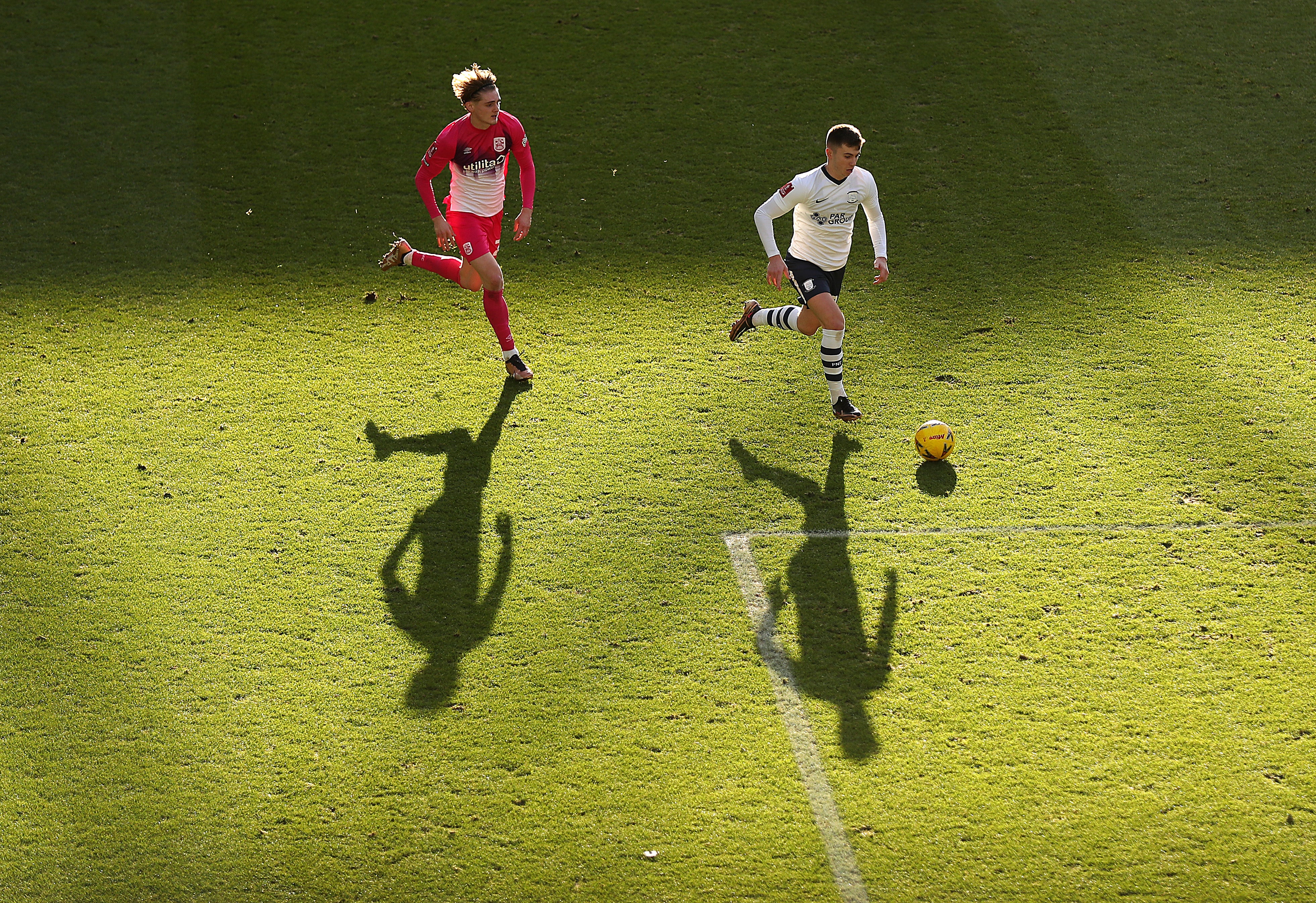 Ben Woodburn of Preston is pursued by Jack Rudoni of Huddersfield