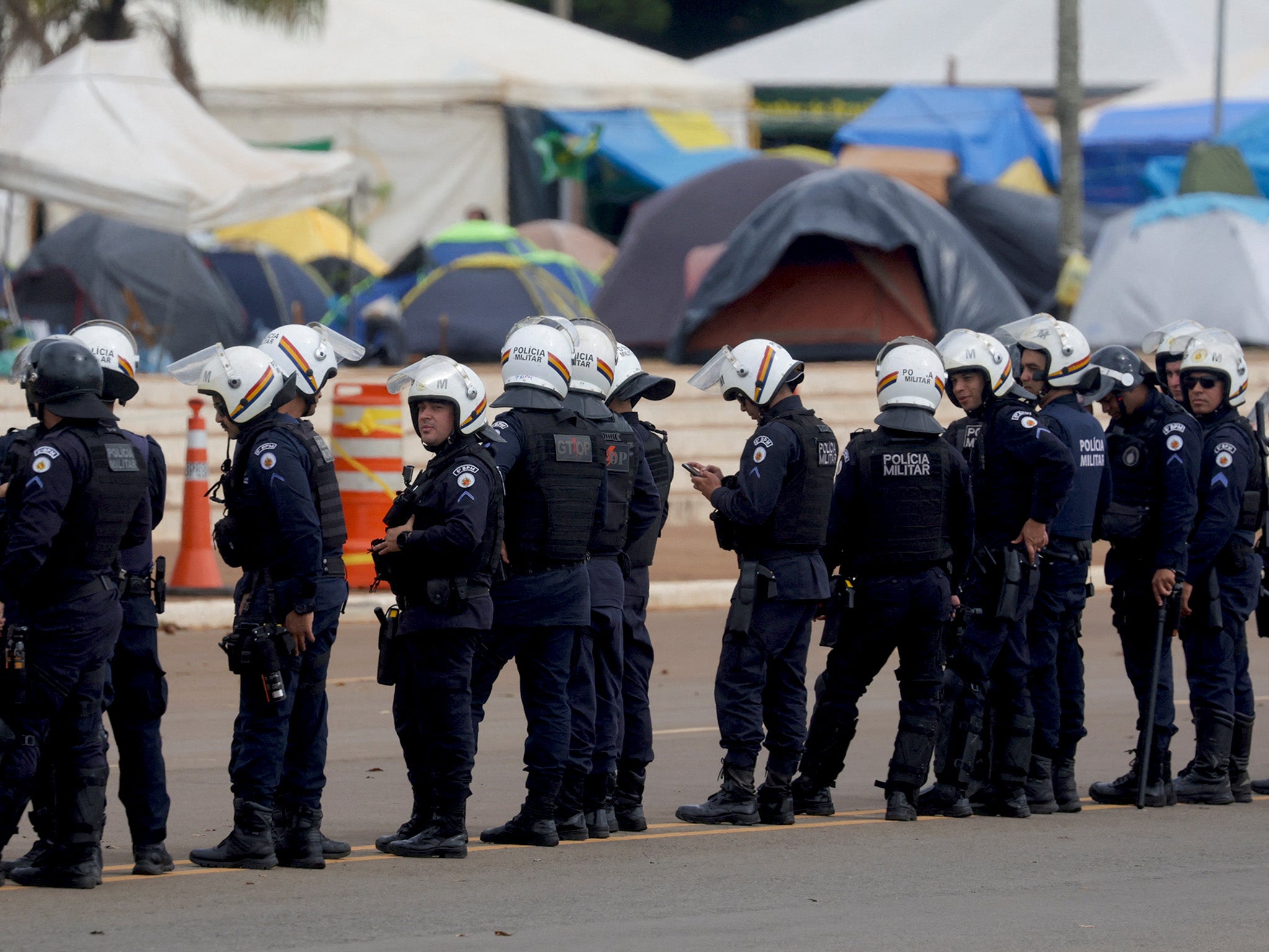 Security forces stand guard as supporters of Brazil's former President Jair Bolsonaro leave a camp outside the the army headquarters in Brasilia