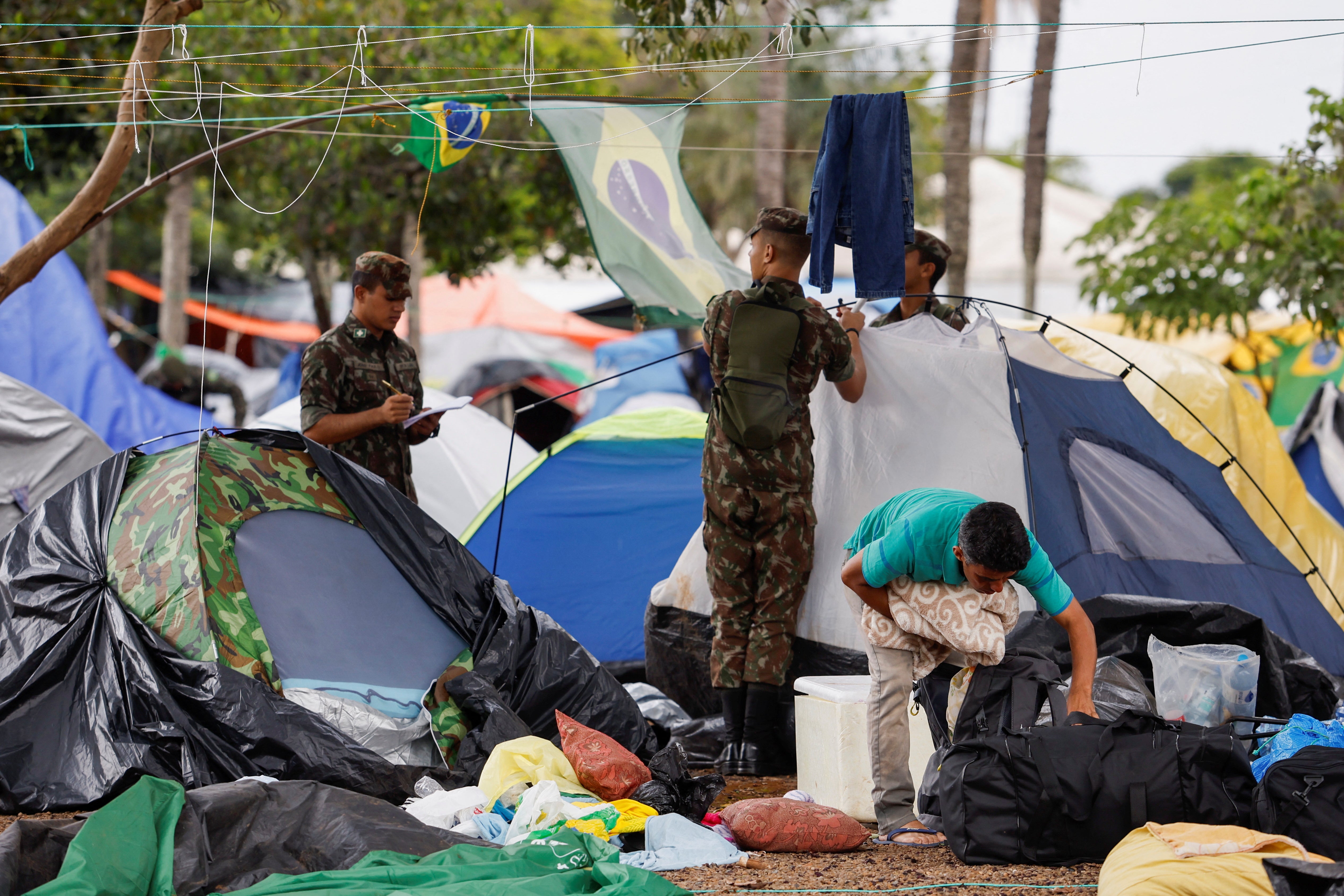 Members of the military take down tents at a camp left by Pro-Bolsonaro supporters