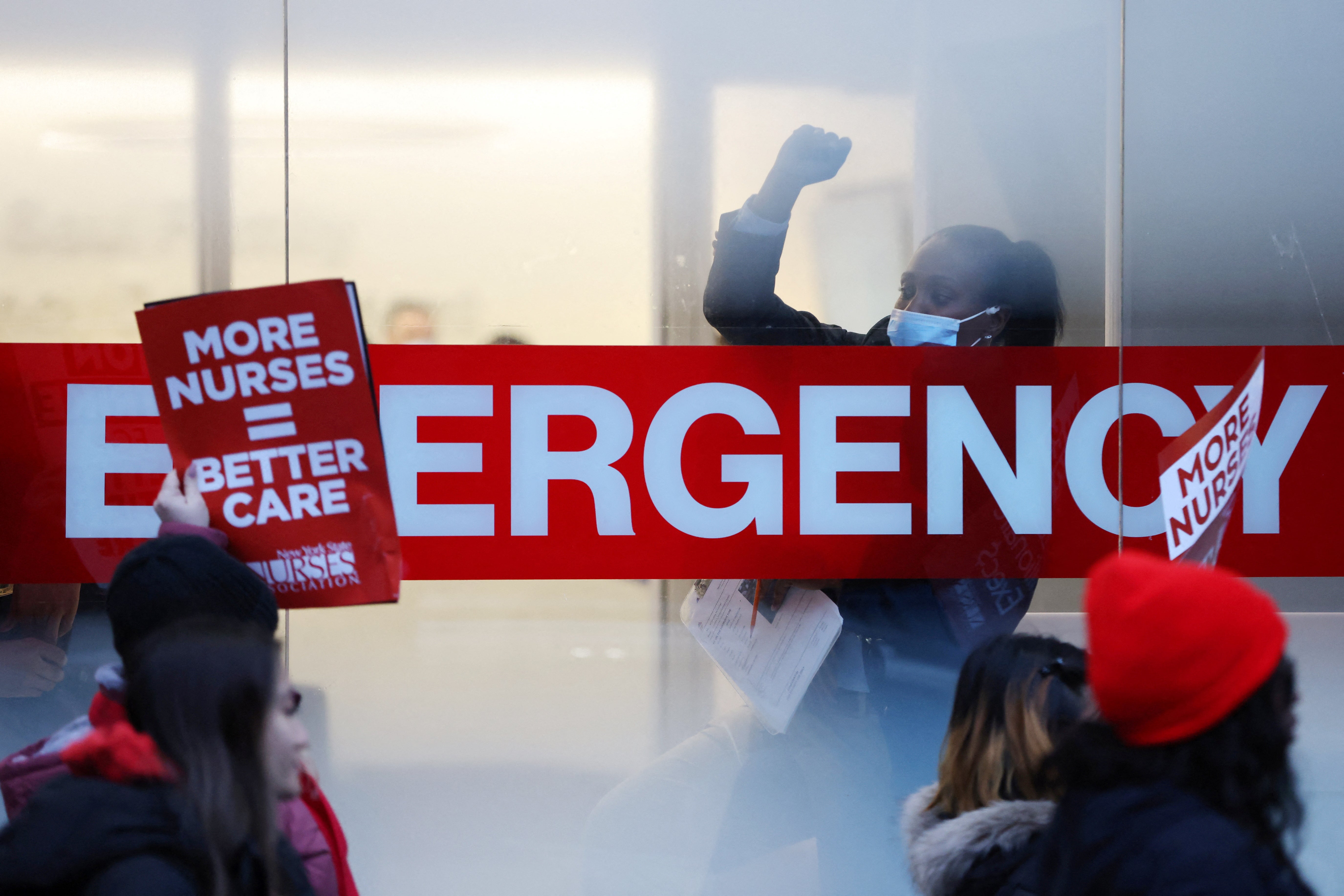 A hospital worker raises a fist as NYSNA nurses walk off the job, to go on strike at Mount Sinai Hospital in New York City, U.S. January 9, 2023