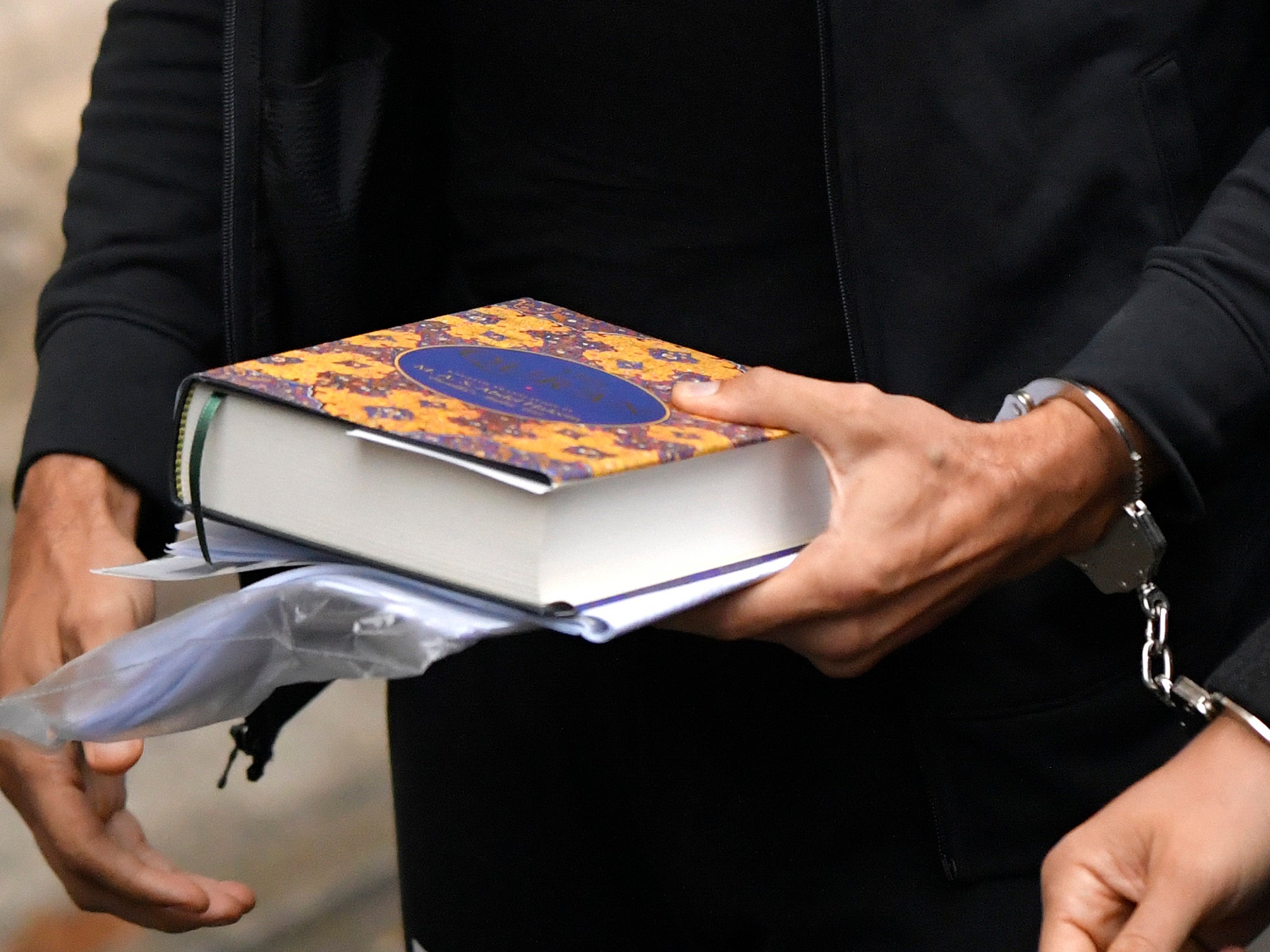 Tate holding the Quran as he went into court on Tuesday