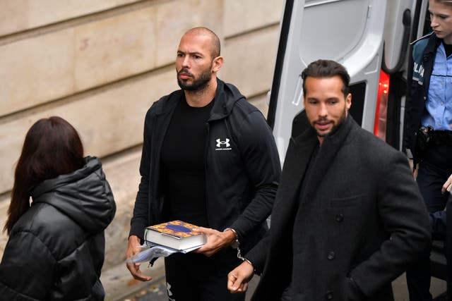 <p>Andrew Tate, centre, and his brother Tristan, right, are brought by police officers to the Court of Appeal, in Bucharest, Romania</p>