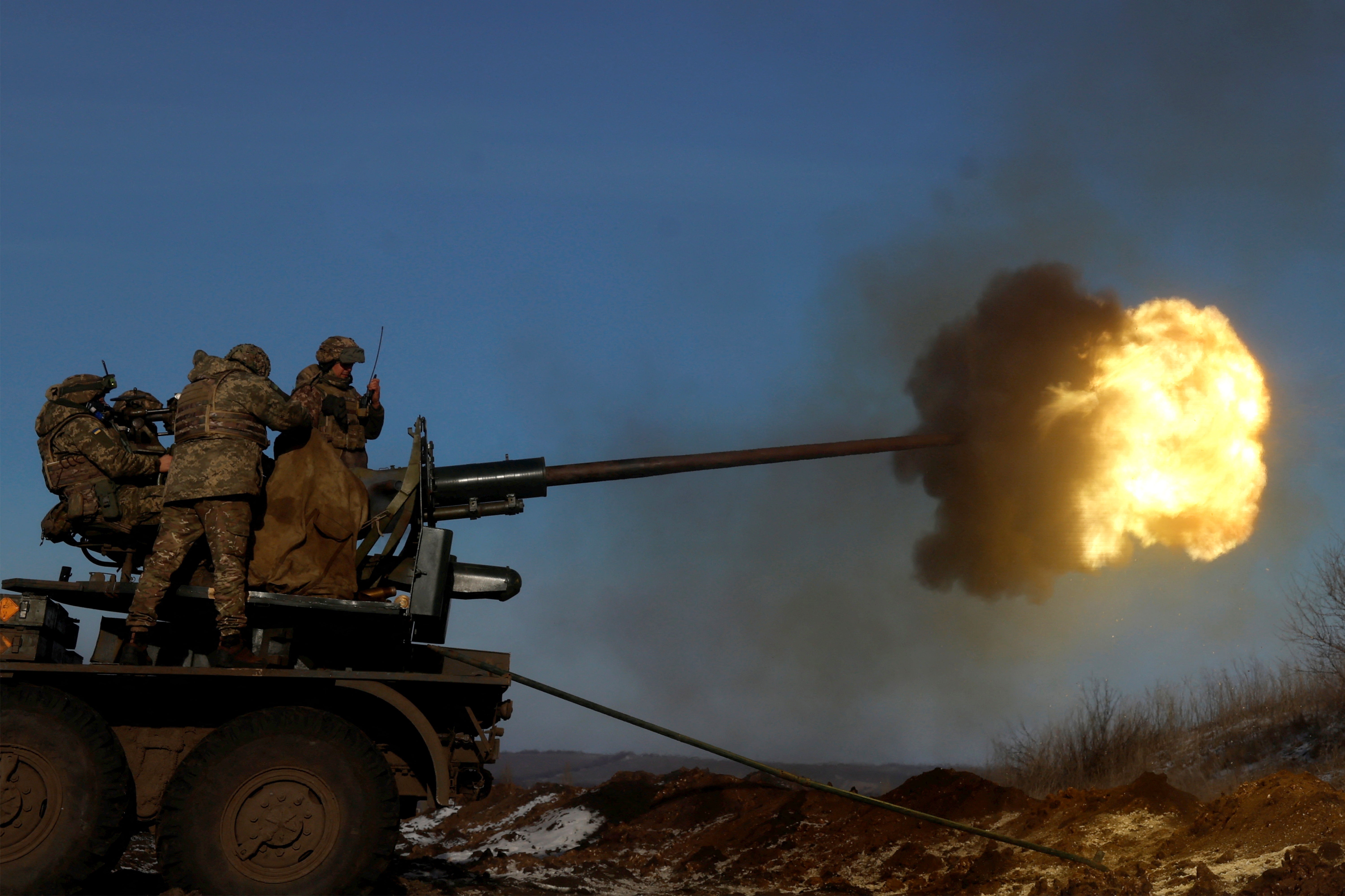 Ukrainian members of the military fire an anti-aircraft weapon in the frontline city of Bakhmut,