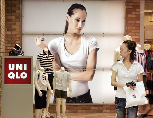 A customers passes before a Uniqlo shop, Japan's casual wear giant operated by the Fast Retailing