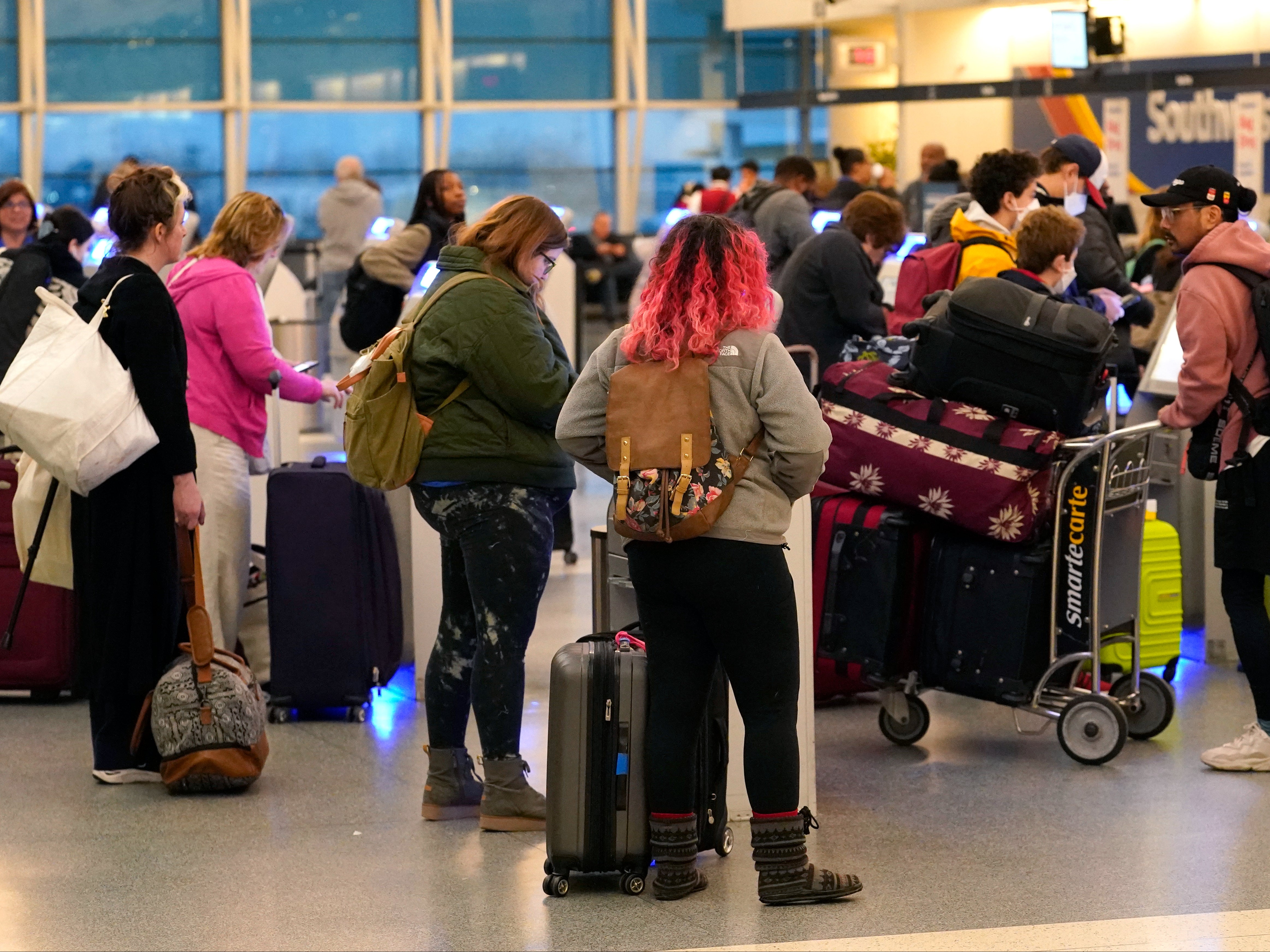 Passengers check in at Southwest Airlines' self serve kiosks at Chicago's Midway Airport as flight delays stemming from a computer outage at the Federal Aviation Administration