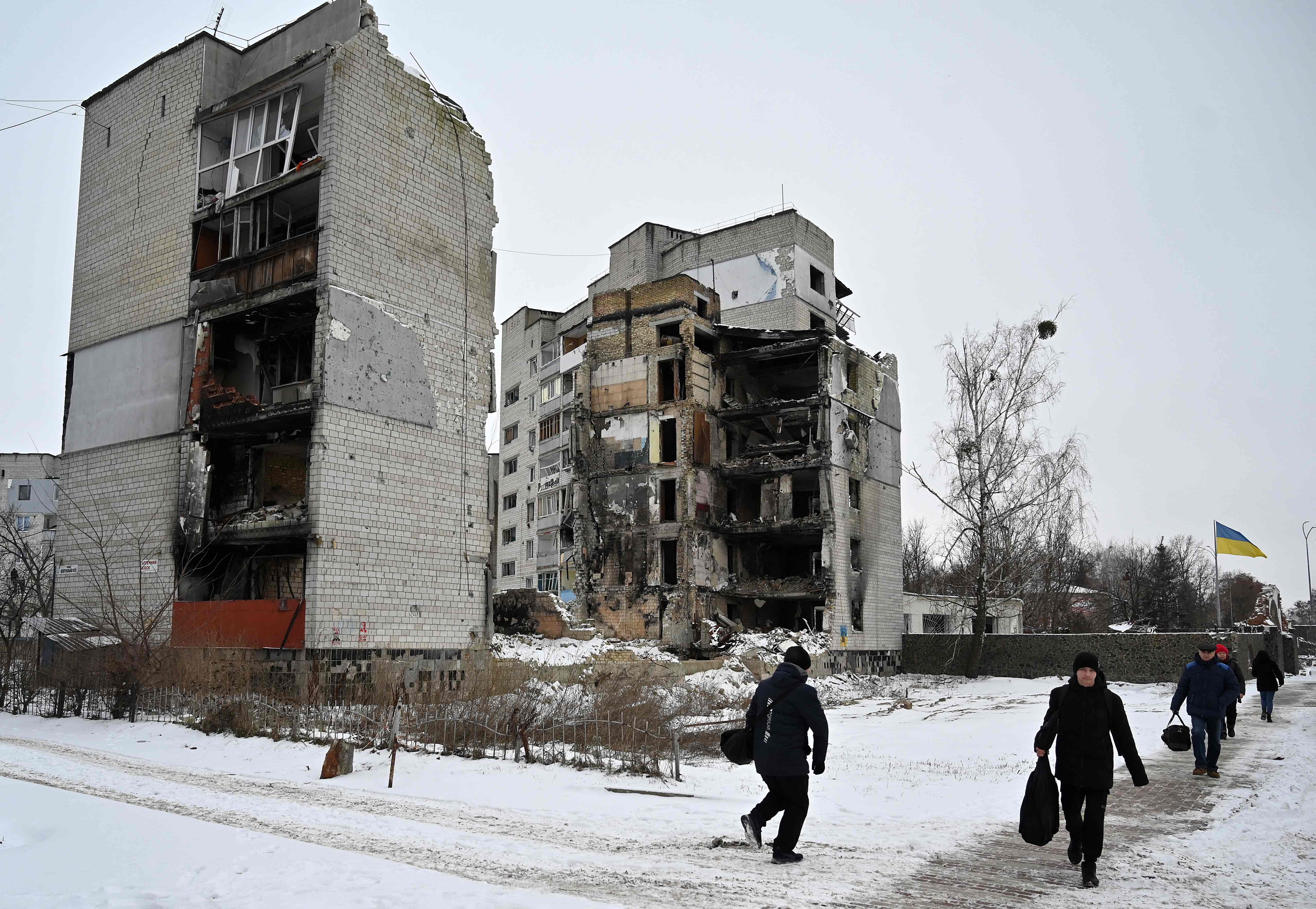 Pedestrians walk past destroyed buildings in the small Ukrainian town of Borodyanka