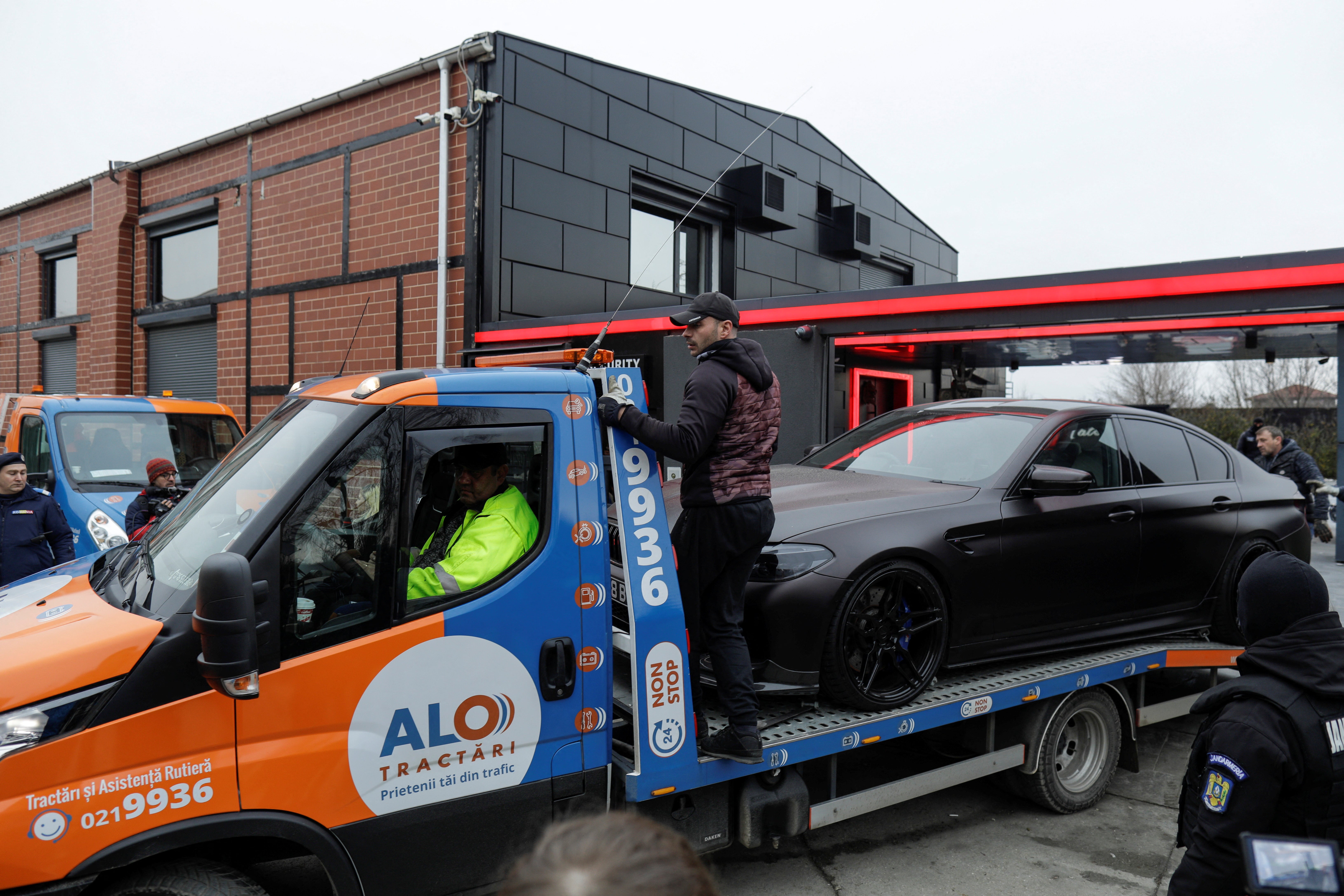 Romanian officials transport the cars seized from the Tate compound to an undisclosed storage location