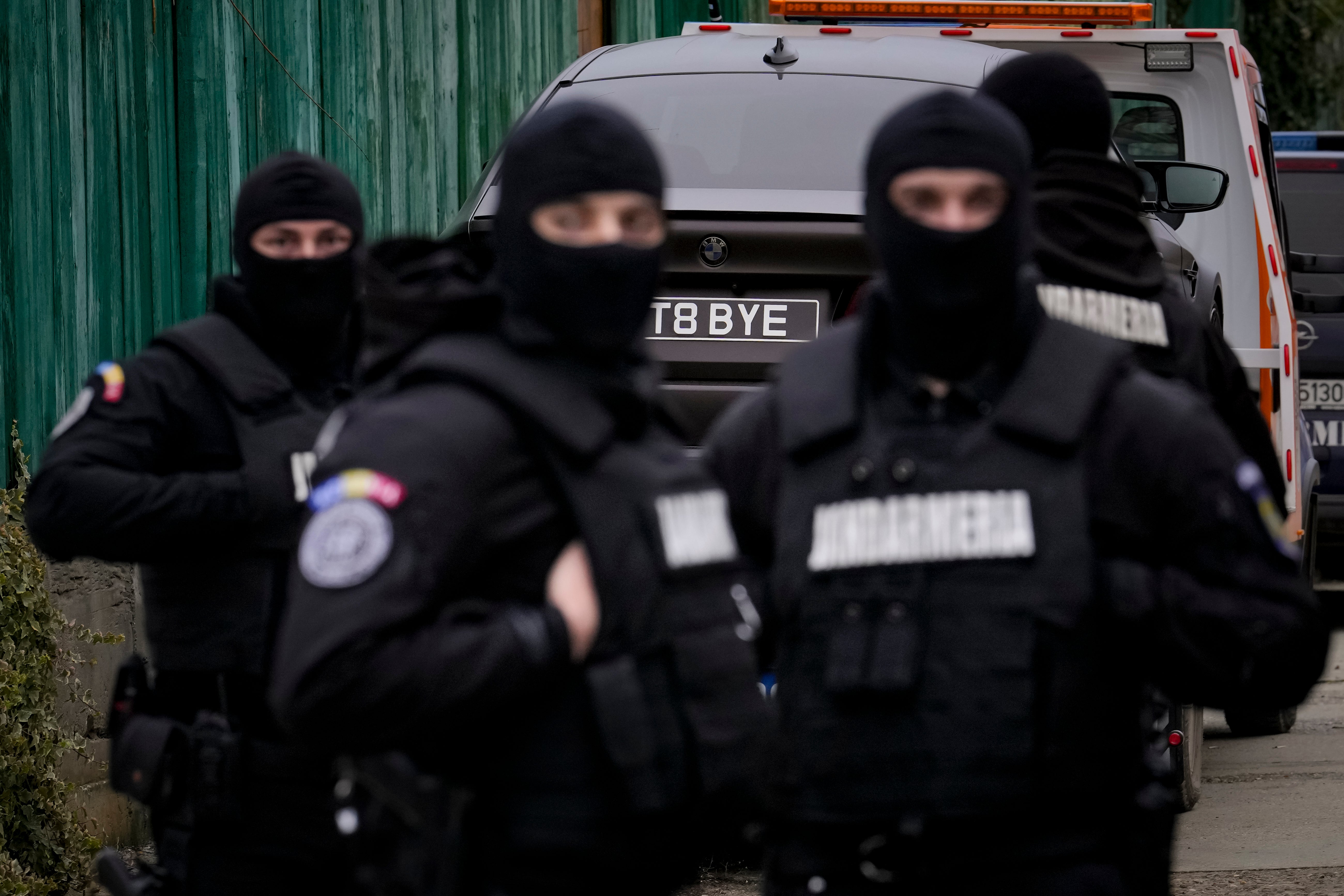 Romanian gendarmes by a car seized at Tate’s estate