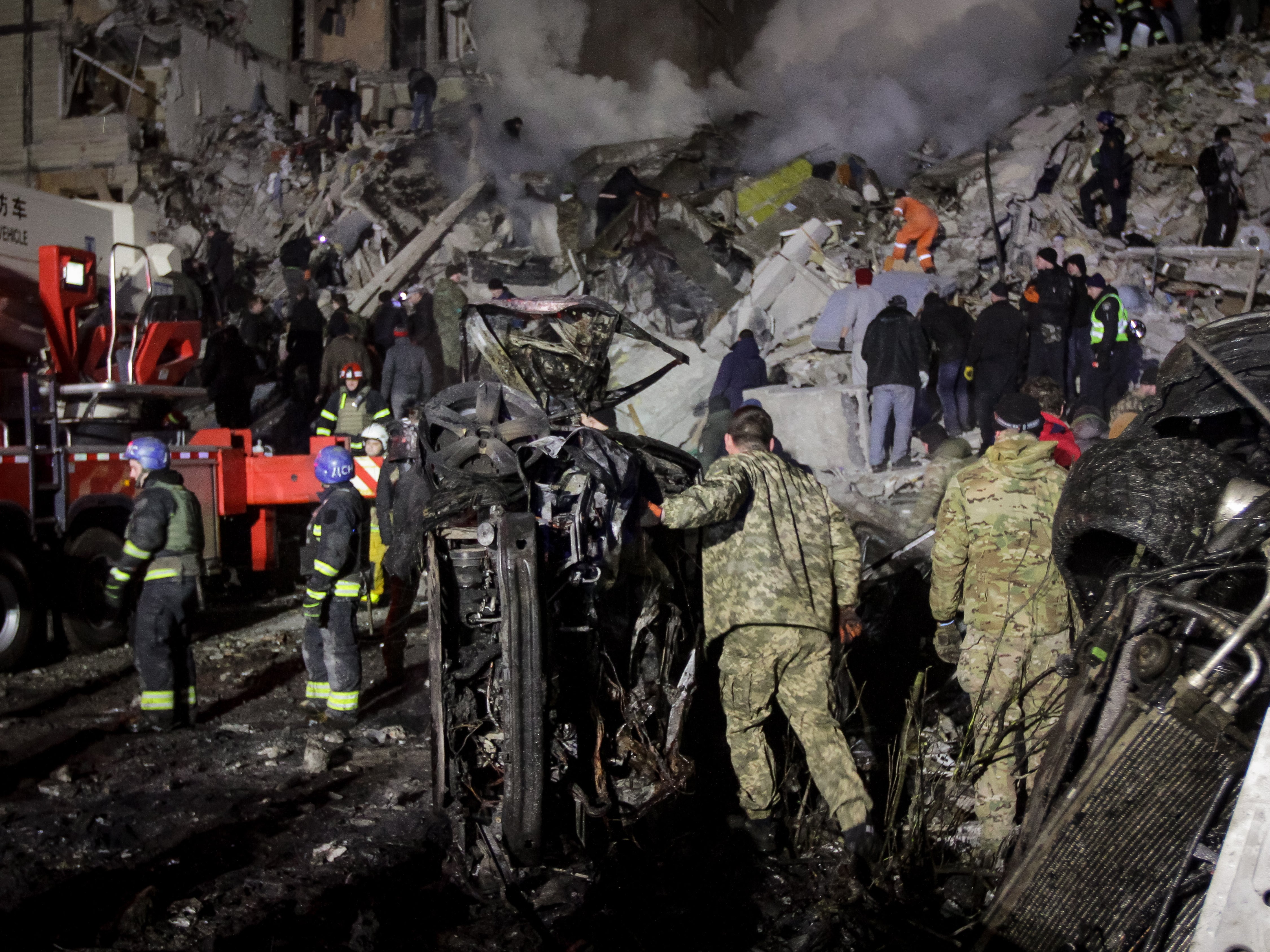 Rescue teams work in the rubble of a residential building hit by shelling in Dnipro