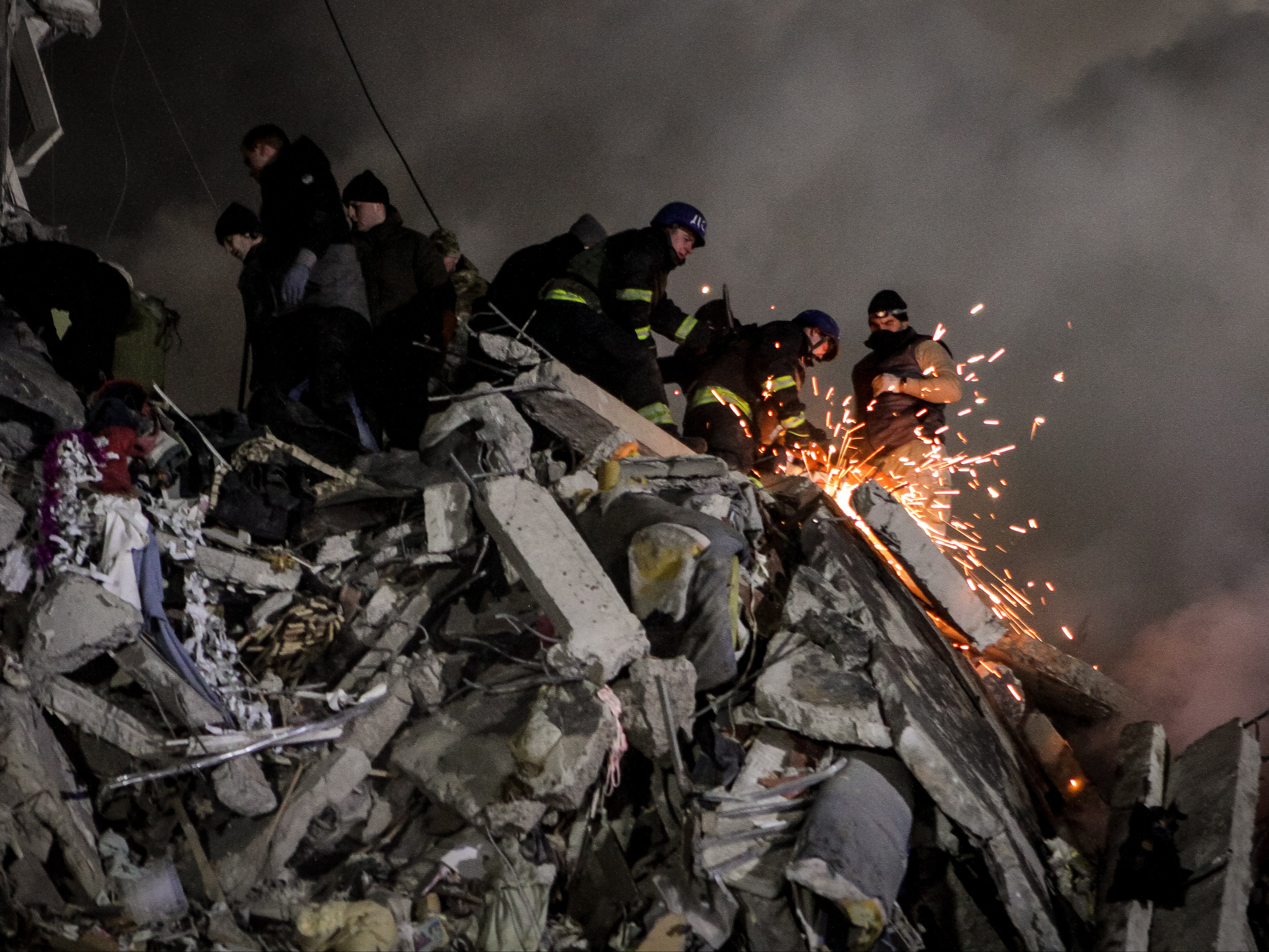 Rescuers try to reach people trapped in rubble in Dnipro