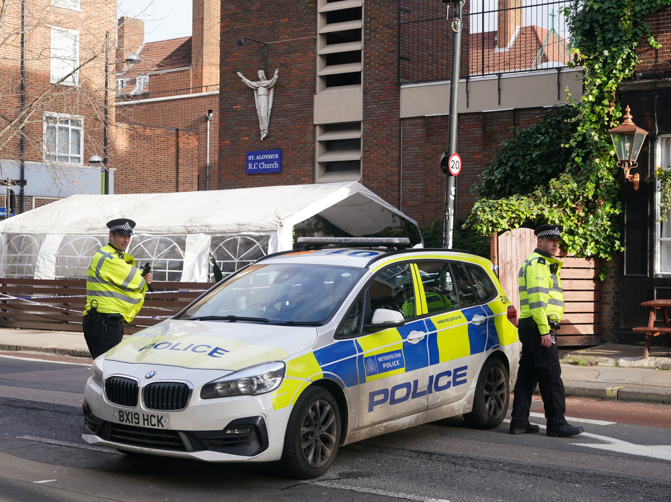 Police at the scene of a shooting outside a memorial service which was being held in St Aloysius Roman Catholic Church on Phoenix Road