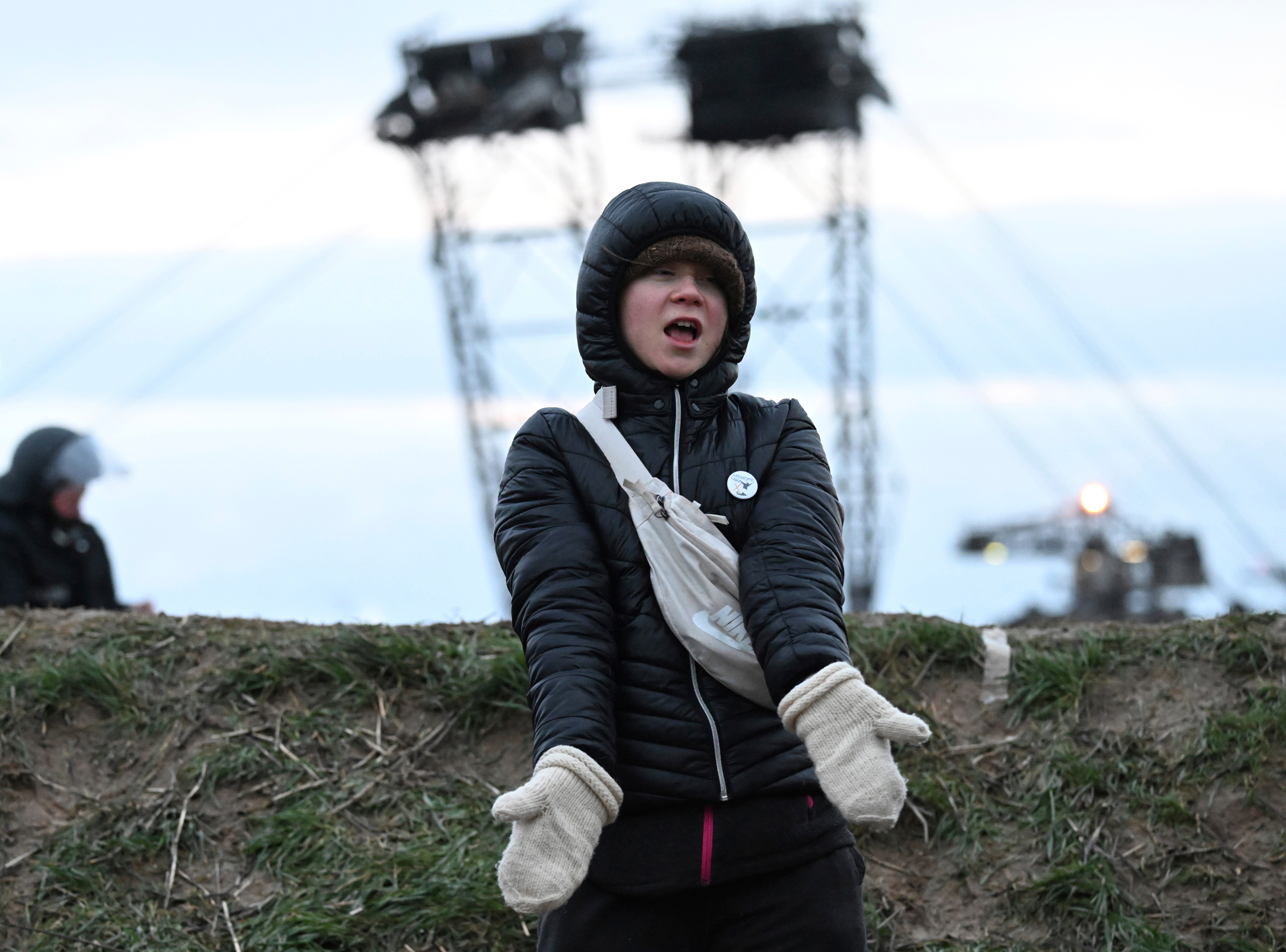 Thunberg stands between Keyenberg and Lützerath under police guard on the edge of an open pit mine