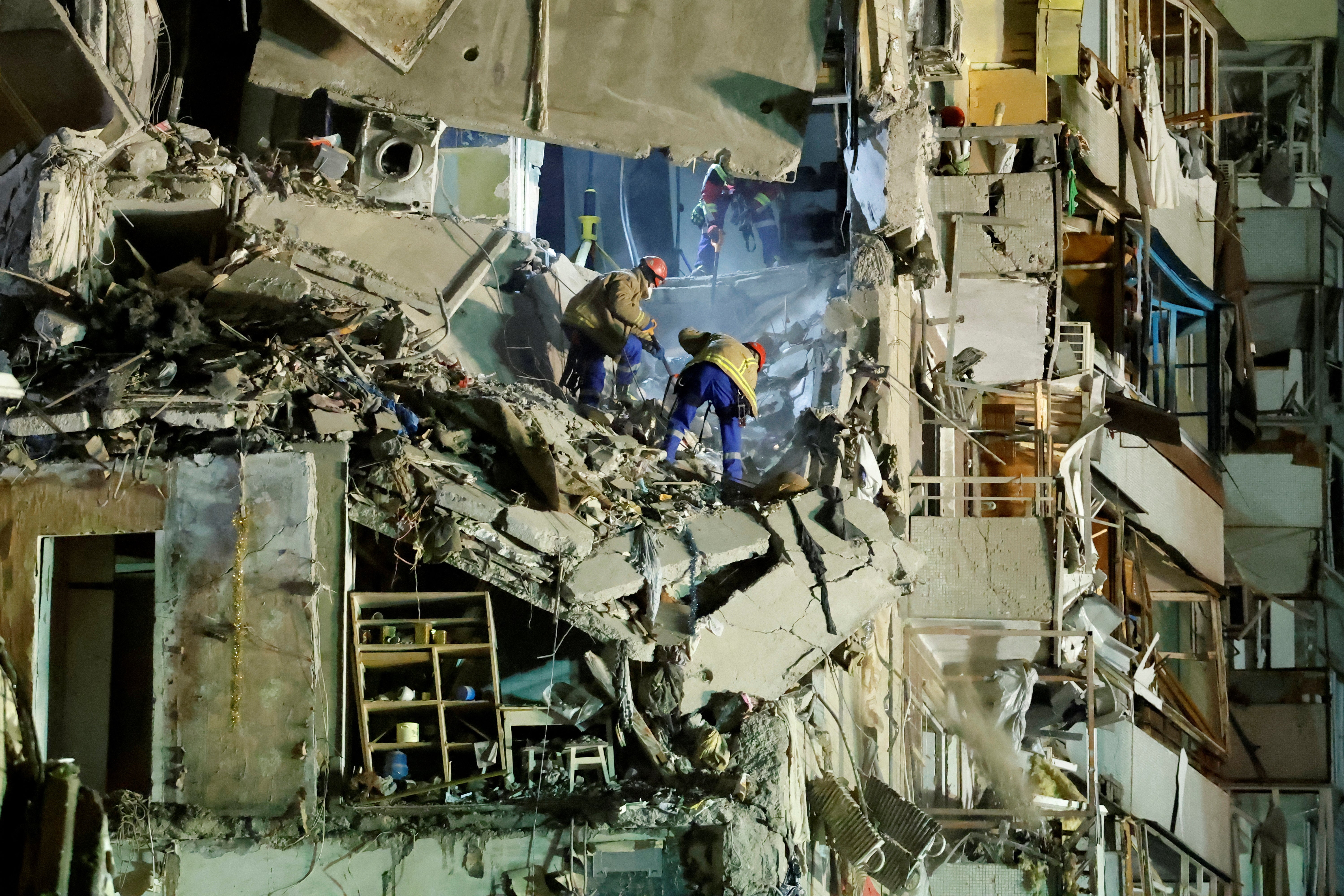 Emergency personnel work at the site where a tower block was heavily damaged by a Russian missile strike in Dnipro