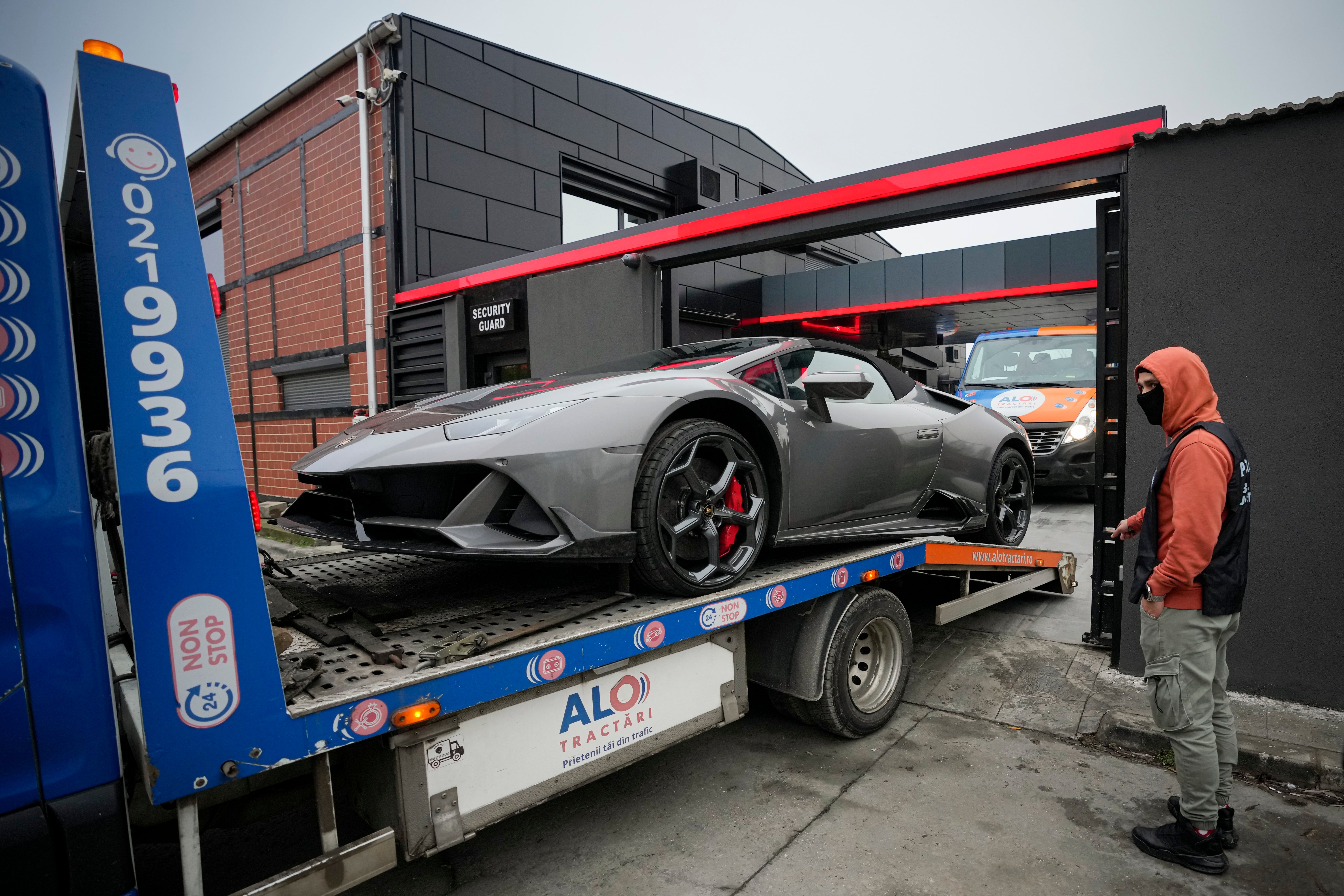 A Porsche is removed from Tate’s Bucharest home on Saturday