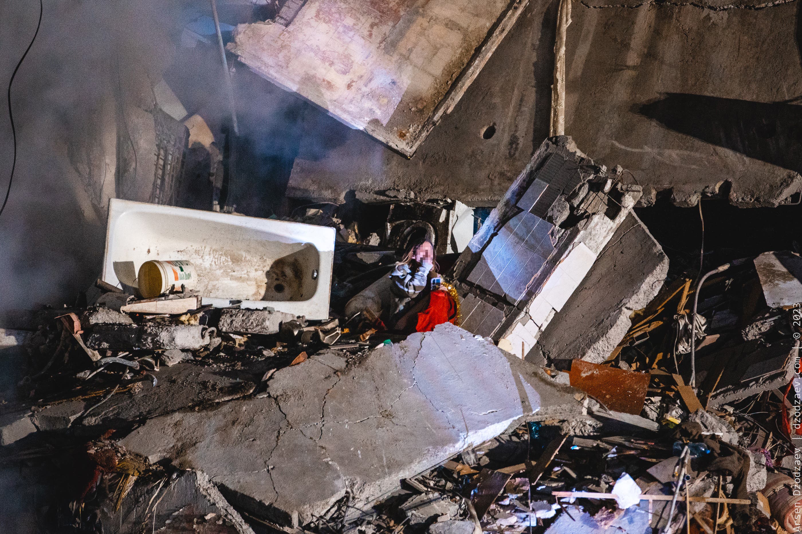 Arsen Dzodzaiev captured the moment a woman lay in the rubble of her home after a Russian airstrike hit a block of flats (Arsen Dzodzaiev/hromadske)