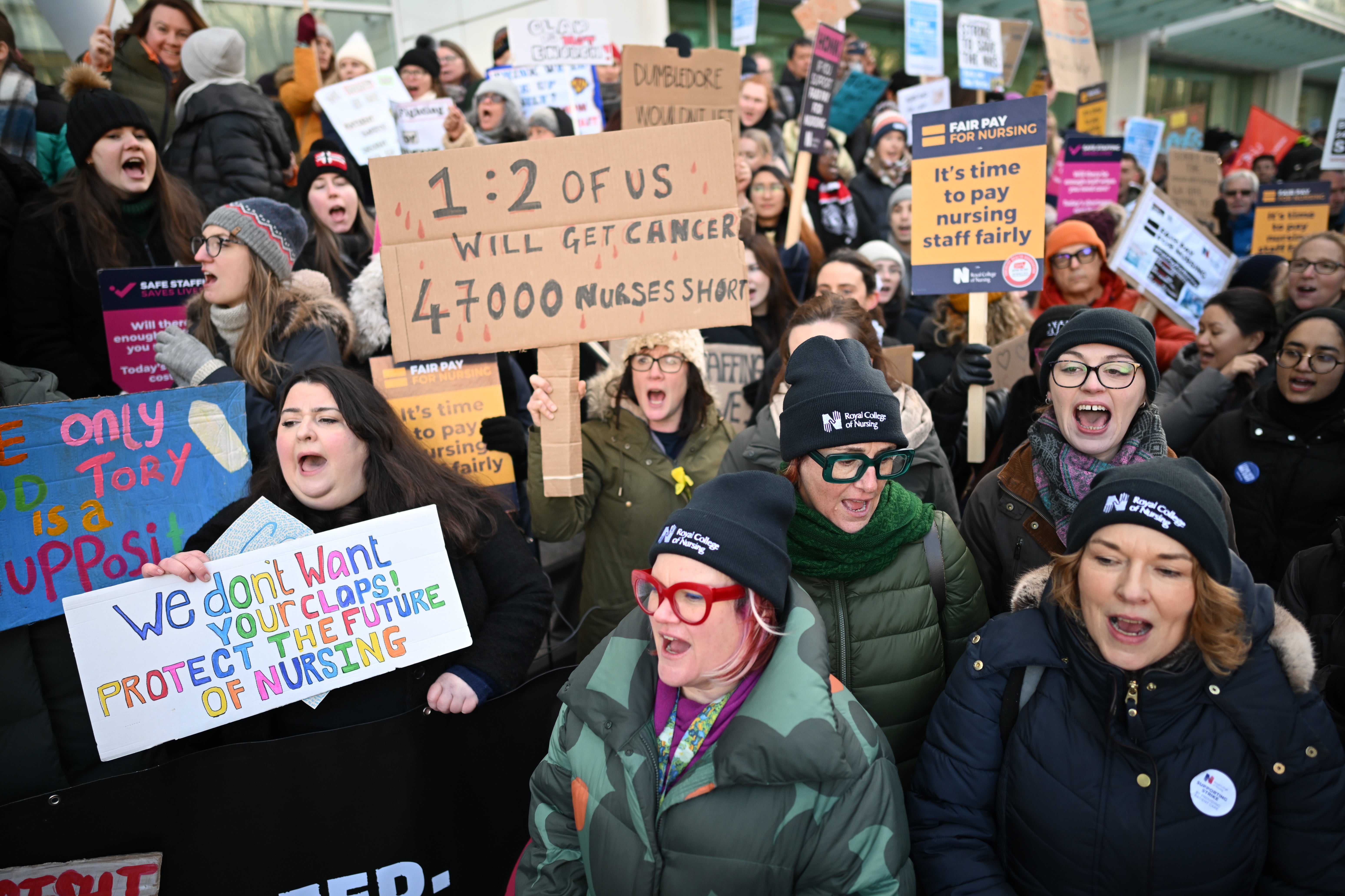 Nursing staff and supporters chant and wave placards outside University College Hospital