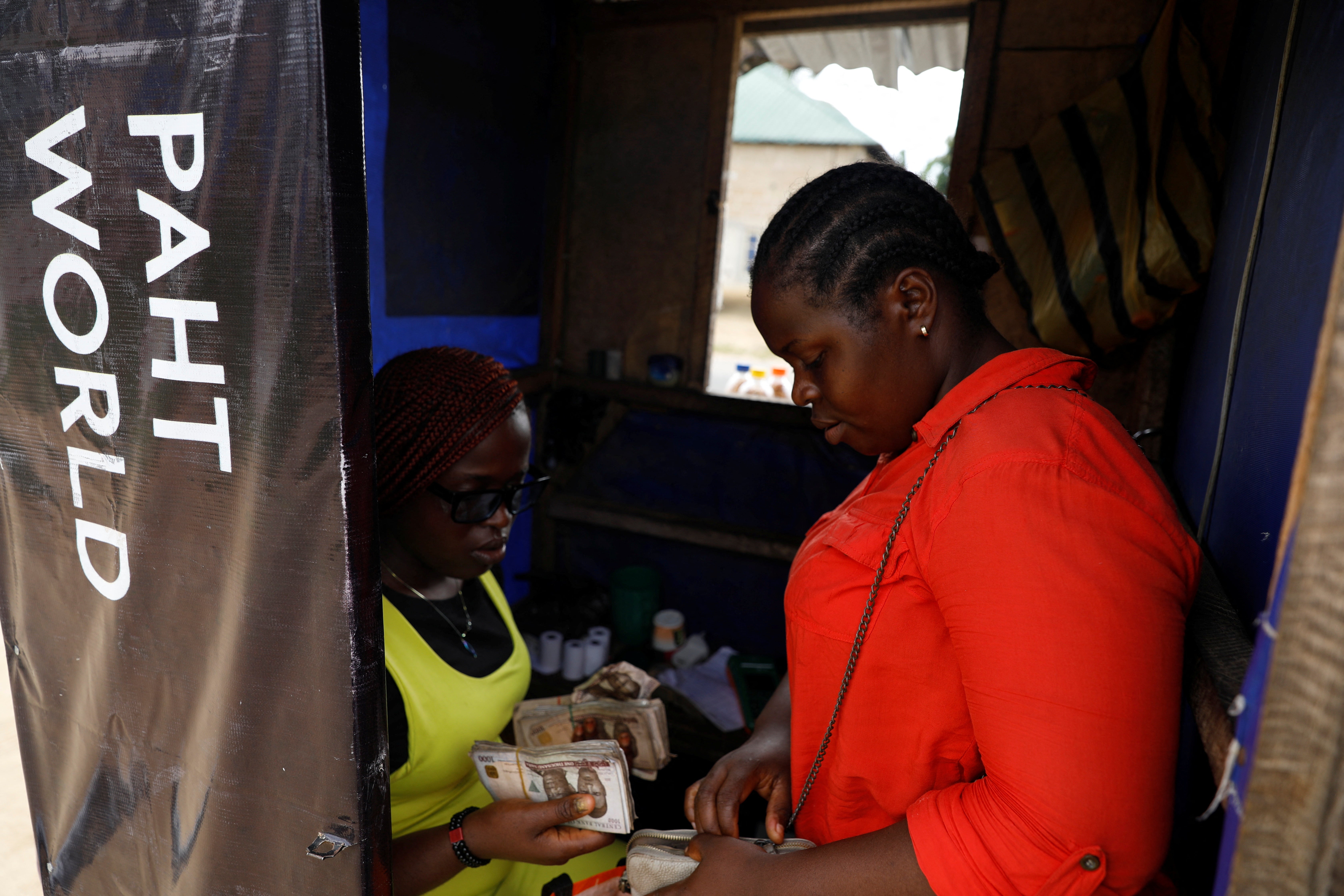 Peace stands with her sister, Joy Ekwere, in her point of sale kiosk in Uyo