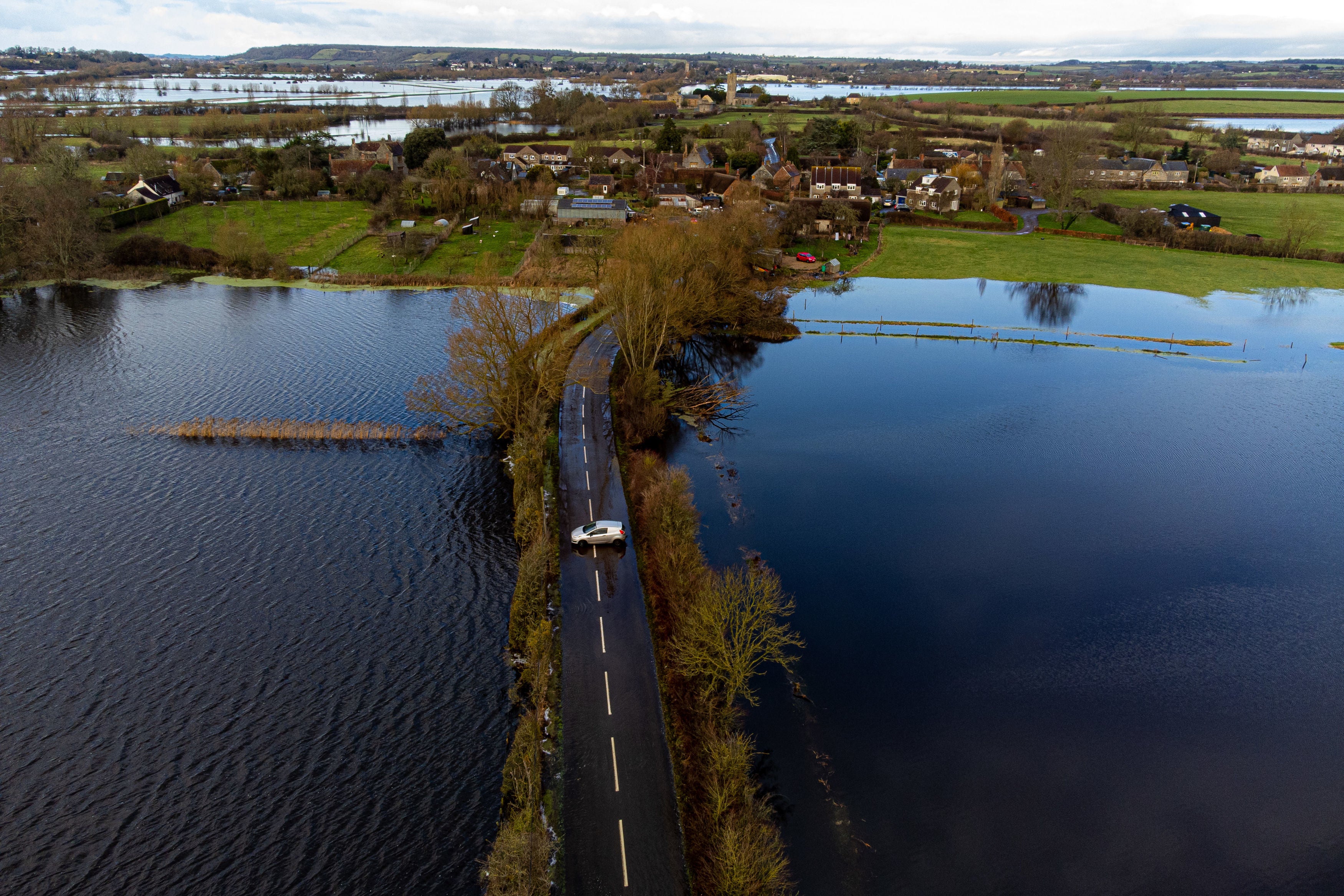 A car turns around in the road to avoid floodwater