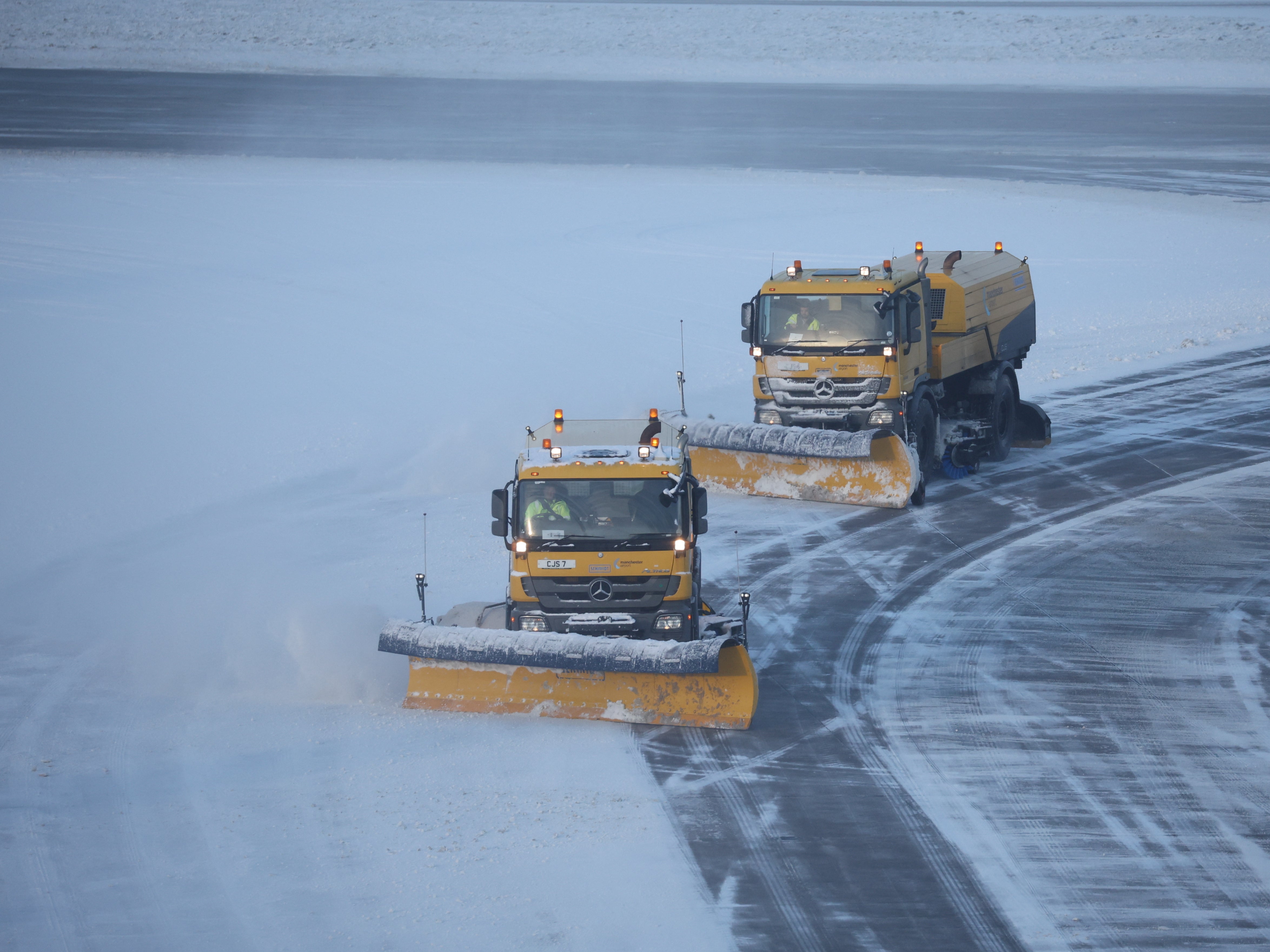 Snow ploughs clear snow from the airfield