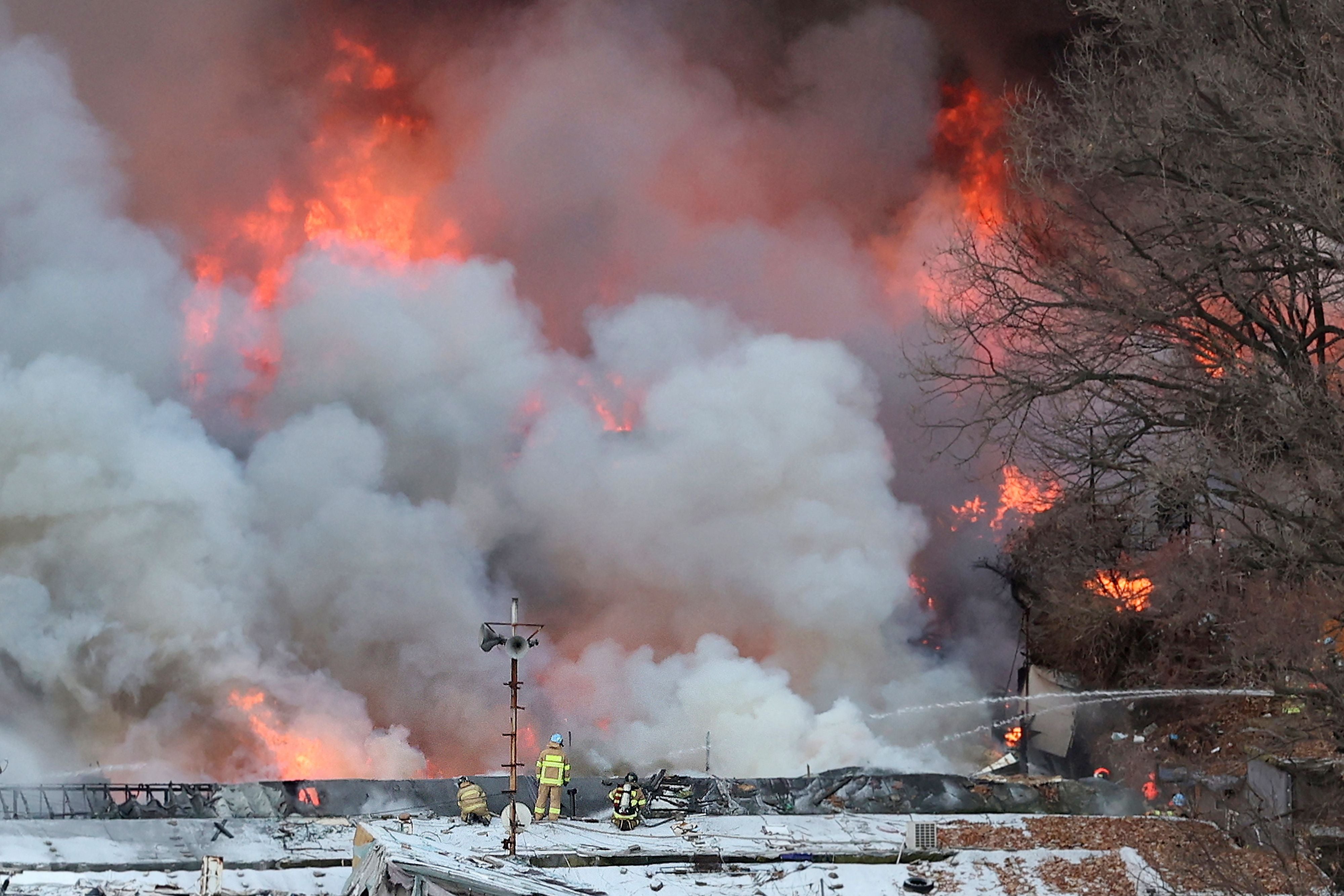 Firefighters try to extinguish a fire at the Guryong village