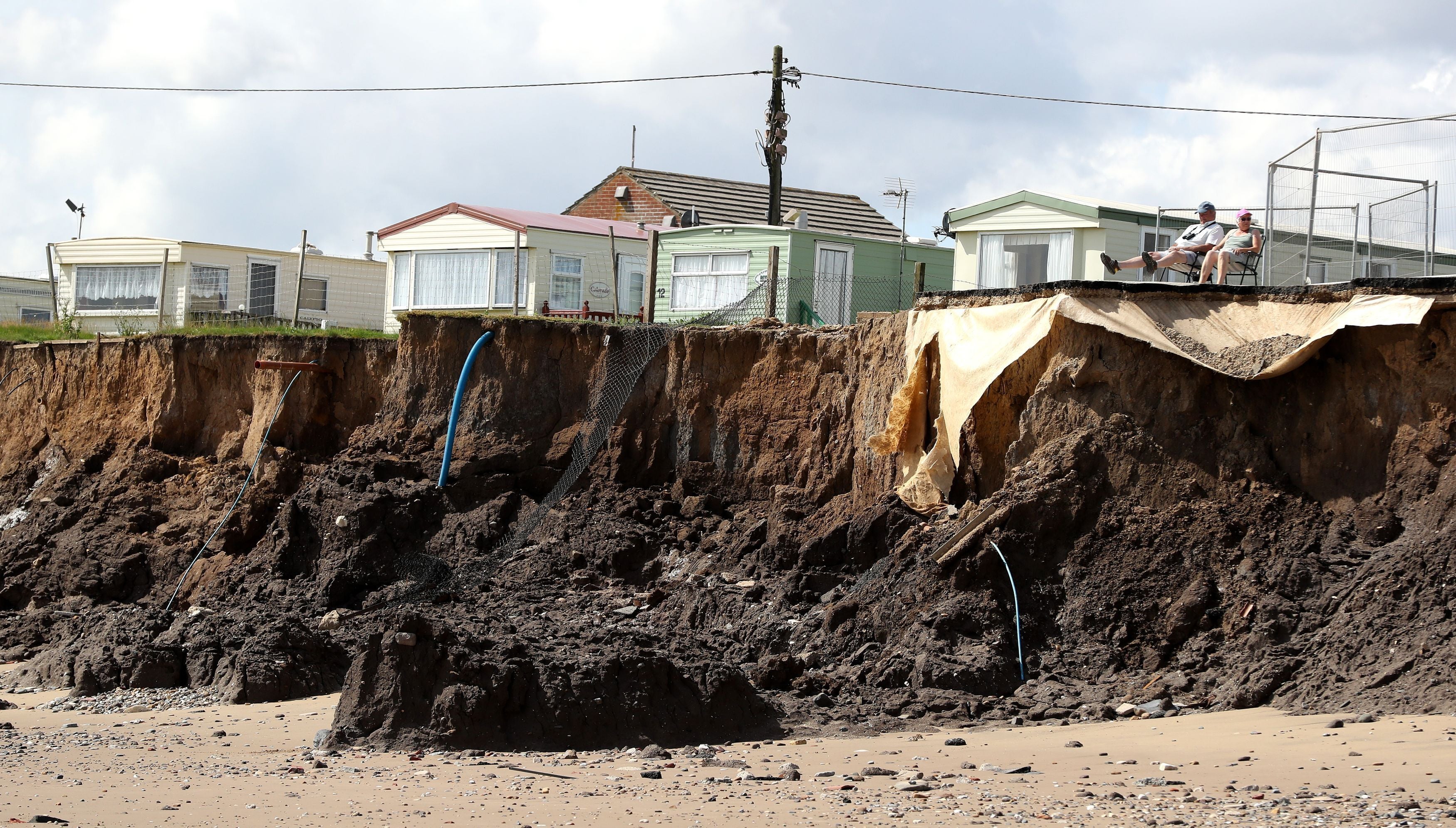 Caravan owners Alan and Mavis Bristow sit in the sun on what used to be a road through Galleon Beach caravan park near Skipsea in 2016