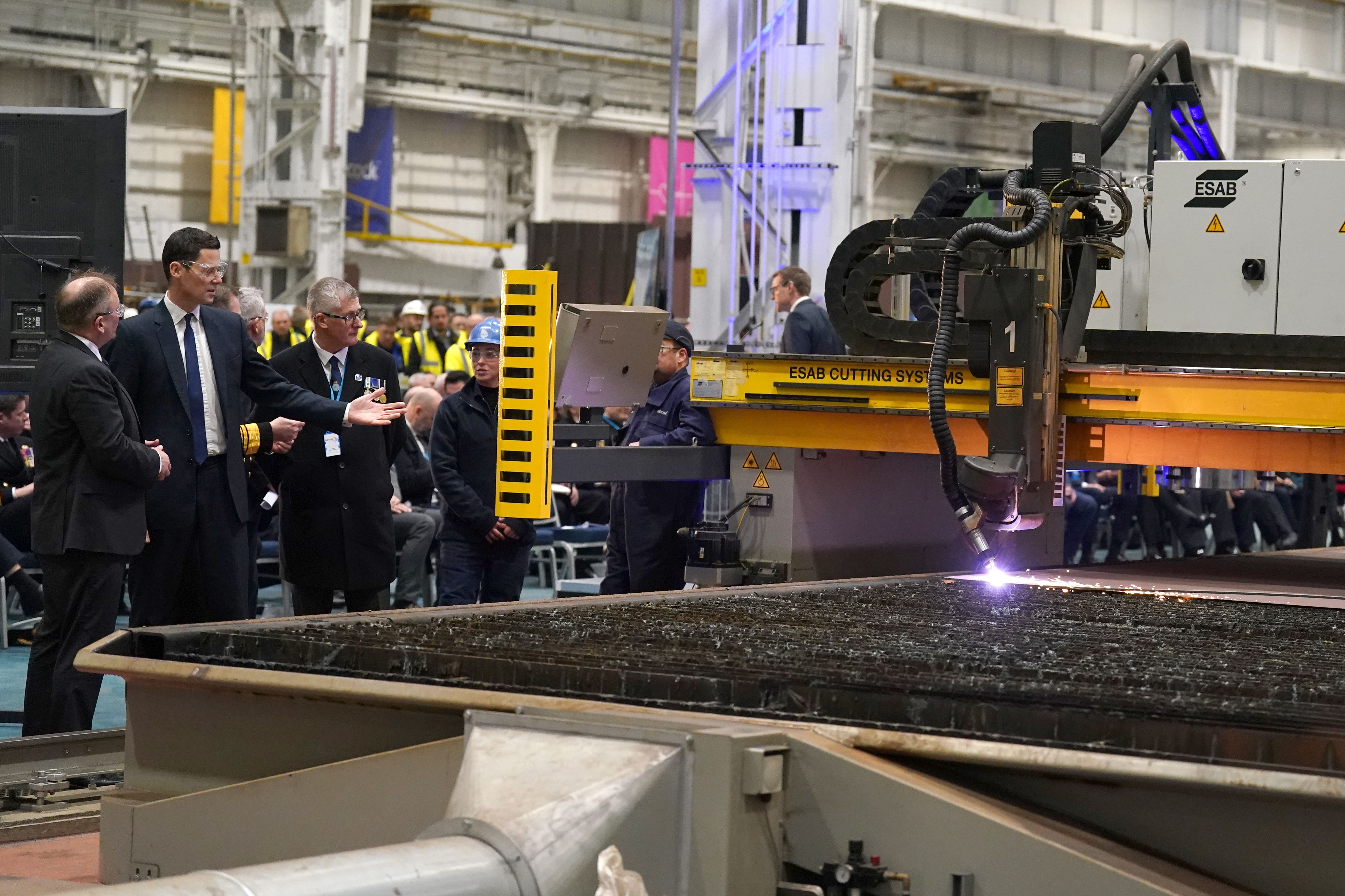 Alex Chalk, second left, makes the first cut of steel for the Royal Navy frigate, HMS Active (Andrew Milligan/PA)