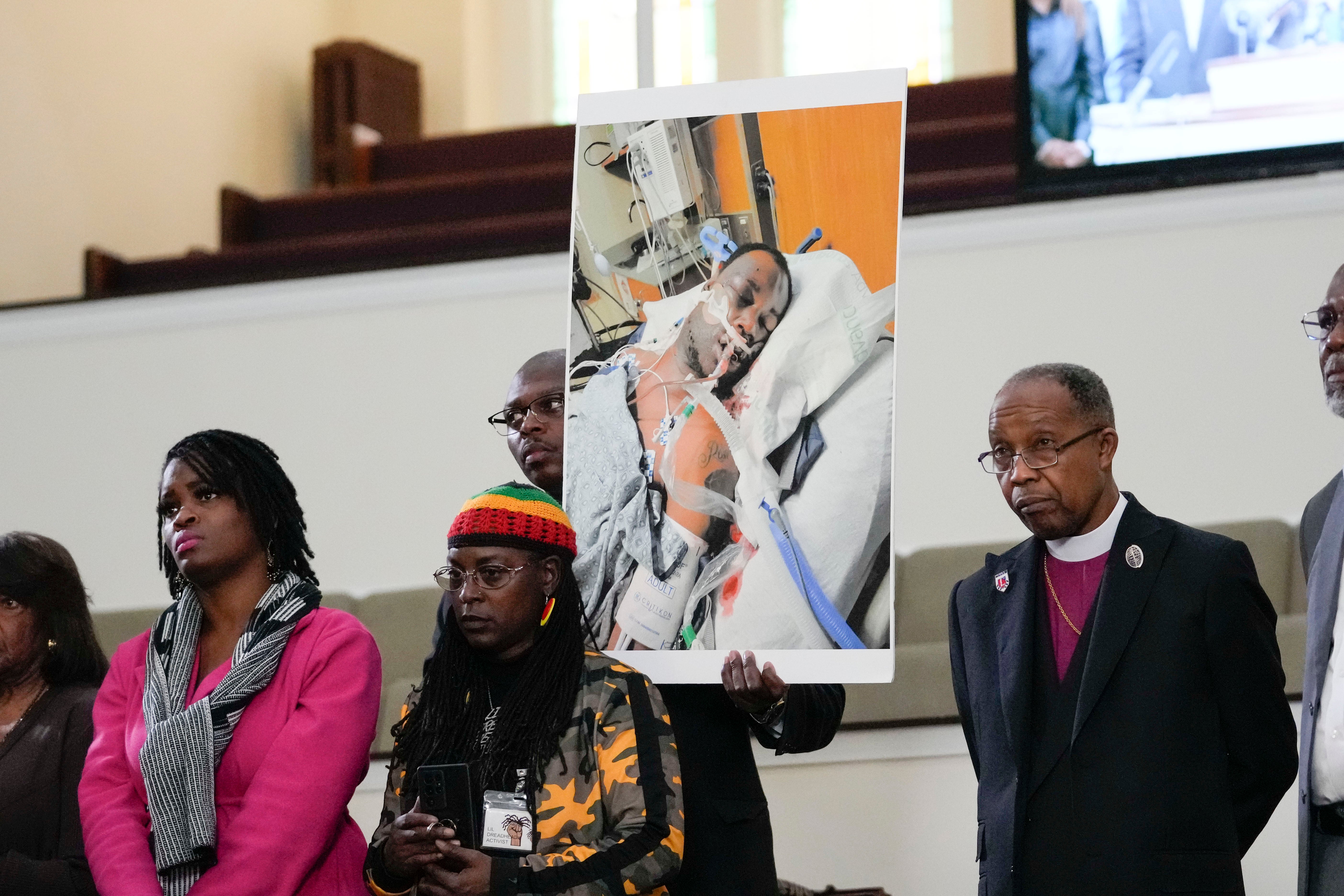 Family members and supporters hold a photograph of Tyre Nichols in hospital during a news conference in Memphis