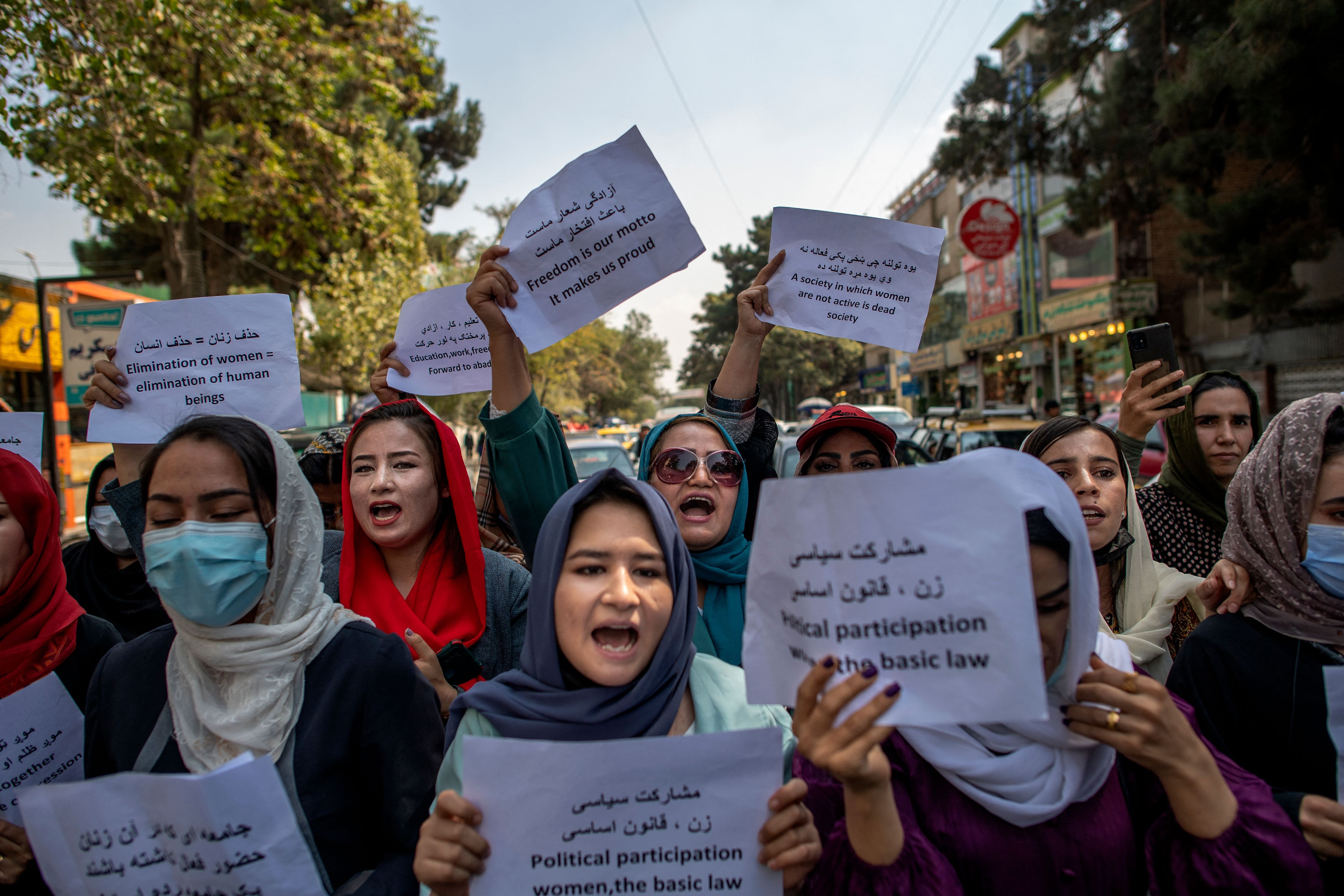 Afghan women hold placards during a demonstration demanding better rights for women in front of the former Ministry of Women Affairs in Kabul