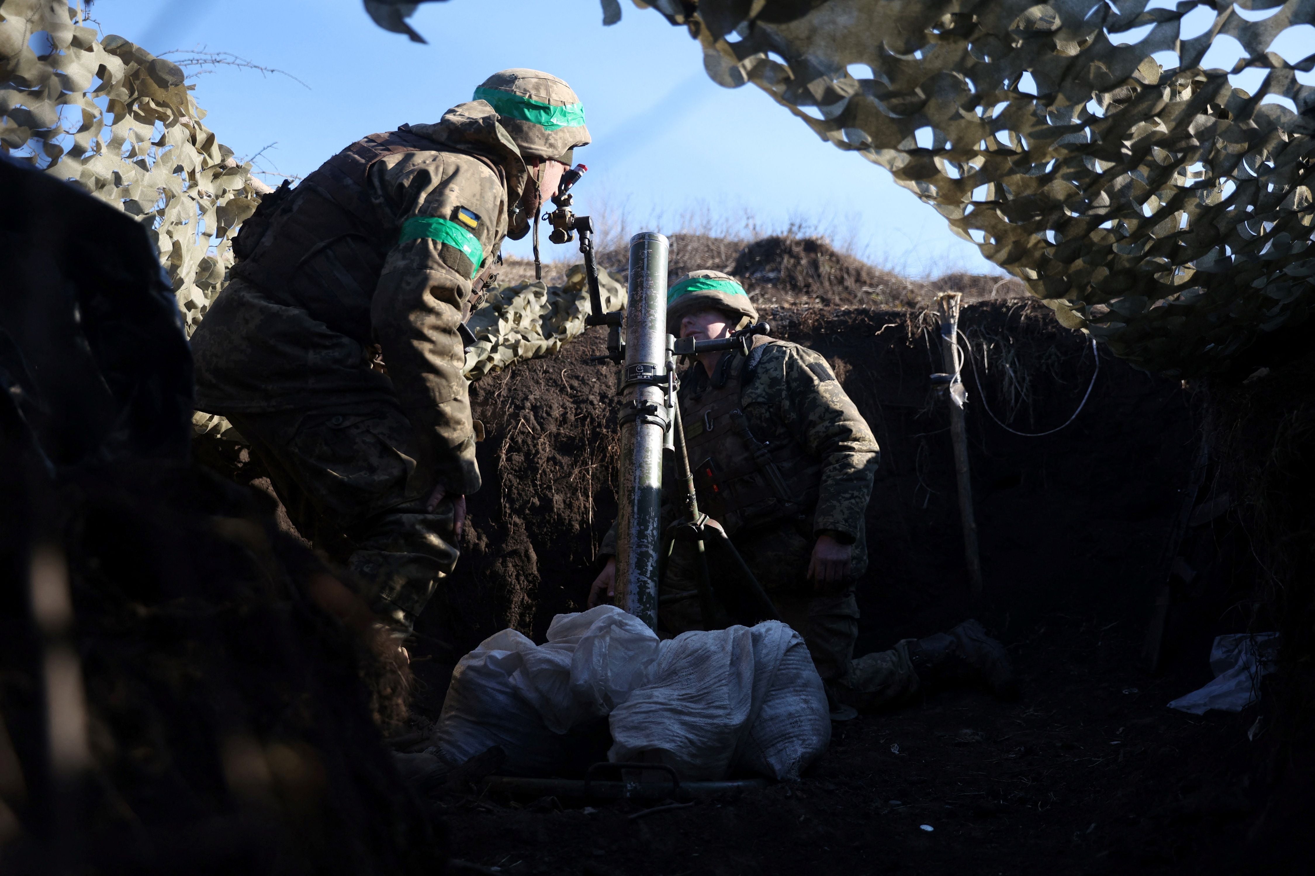 Ukrainian troops prepare to fire a mortar from a position near Bakhmut