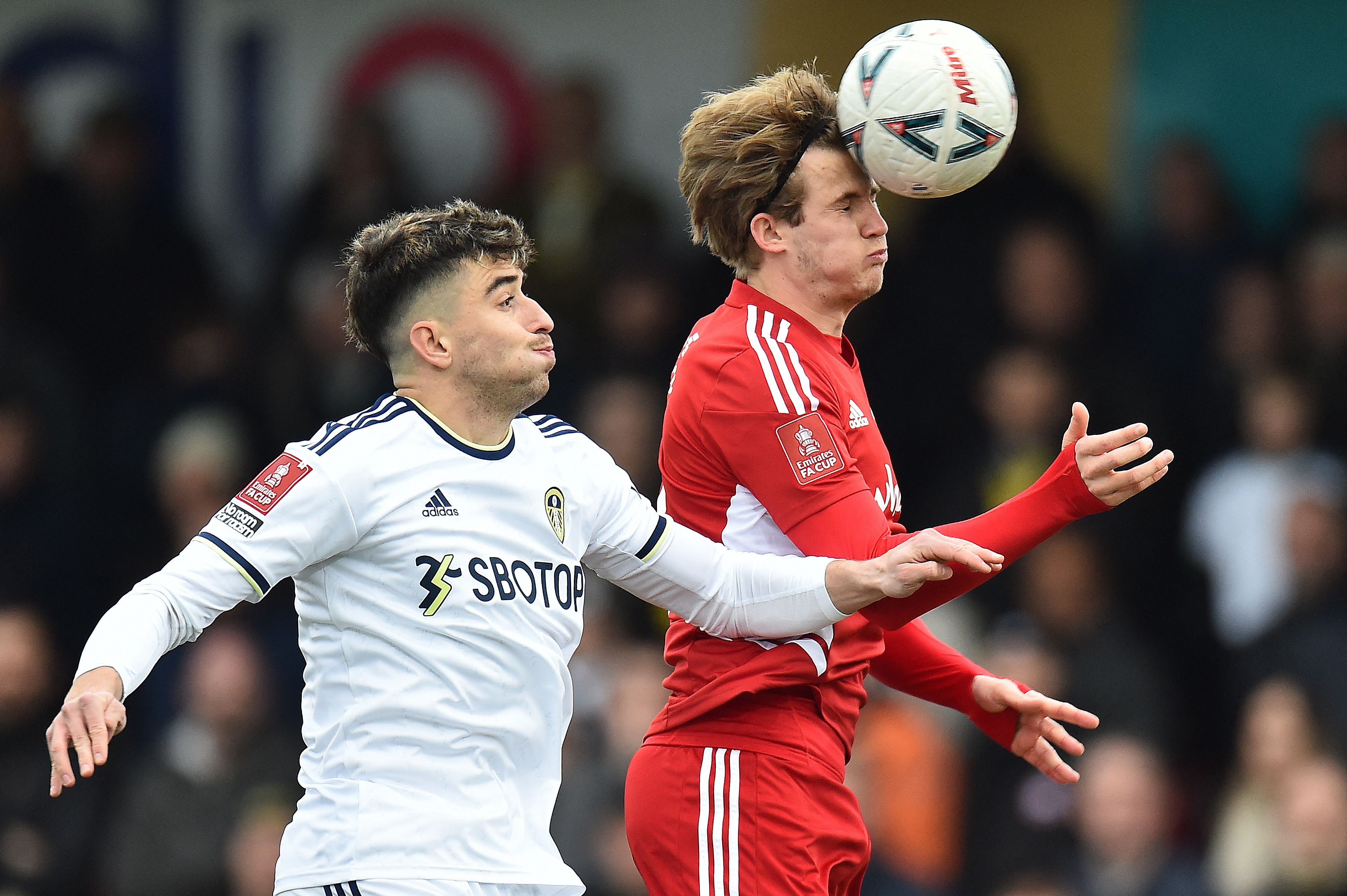 Leeds United's Spanish midfielder Marc Roca (L) vies to header the ball against Accrington Stanley's English midfielder Tommy Leigh