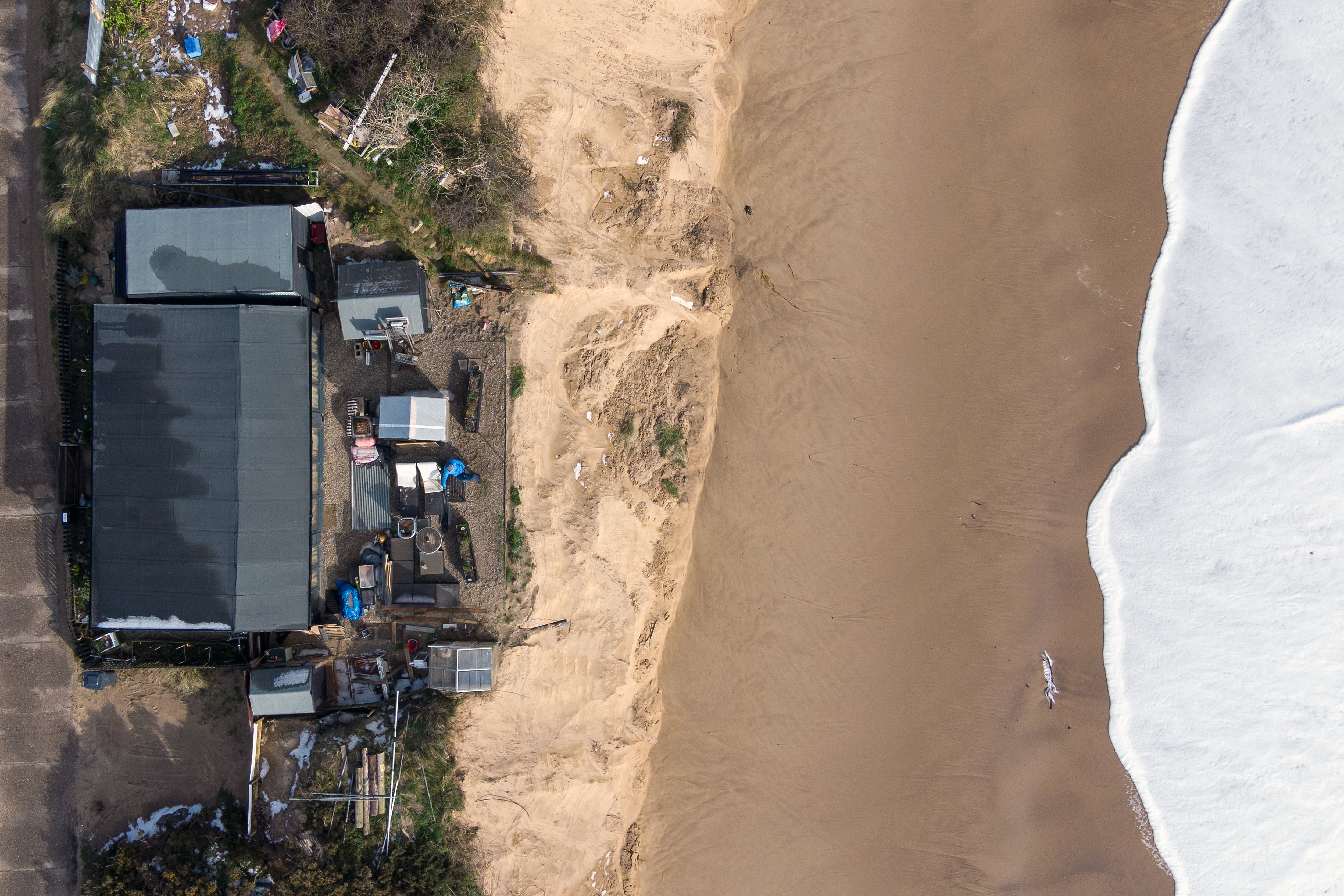 Houses sit on the cliff edge on The Marrams in Hemsby, Norfolk where parts of the cliff have collapsed into the sea.