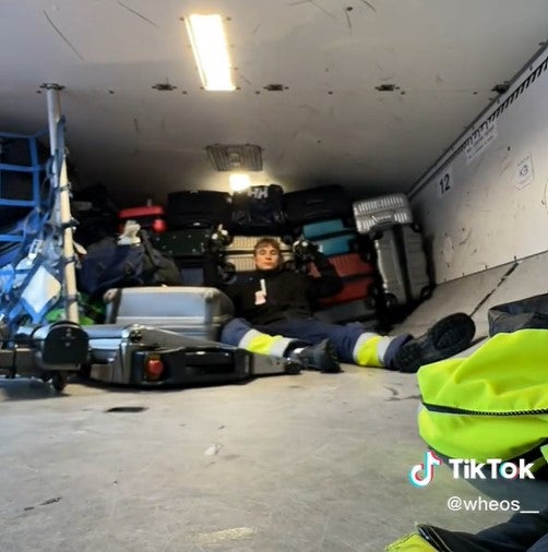 The airport baggage handler poses in front of the first haul of bags