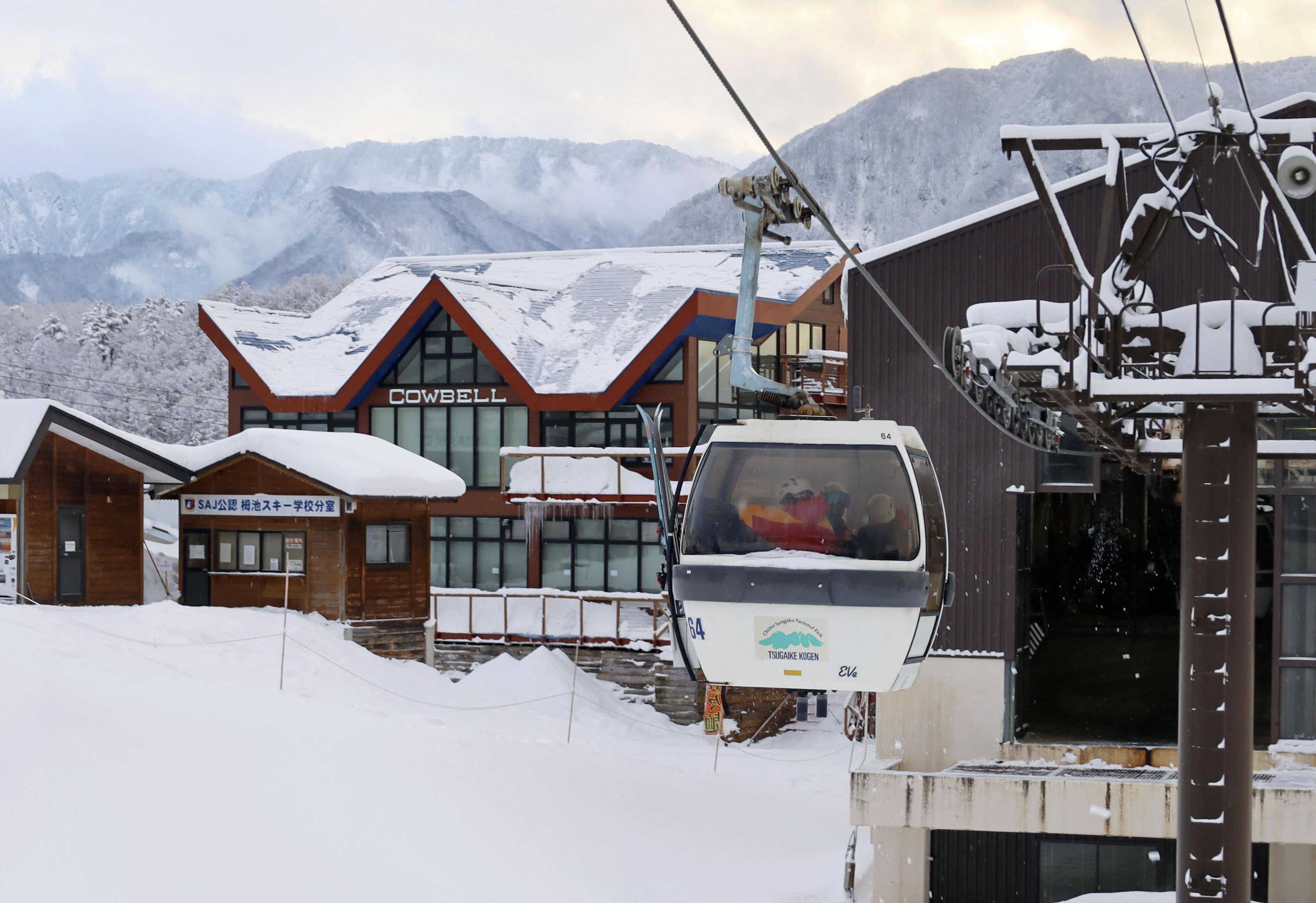 Rescue workers ride a gondola at a ski resort as they take part in a search for missing skiers following an avalanche the previous day, in the village of Otari in Nagano Prefecture