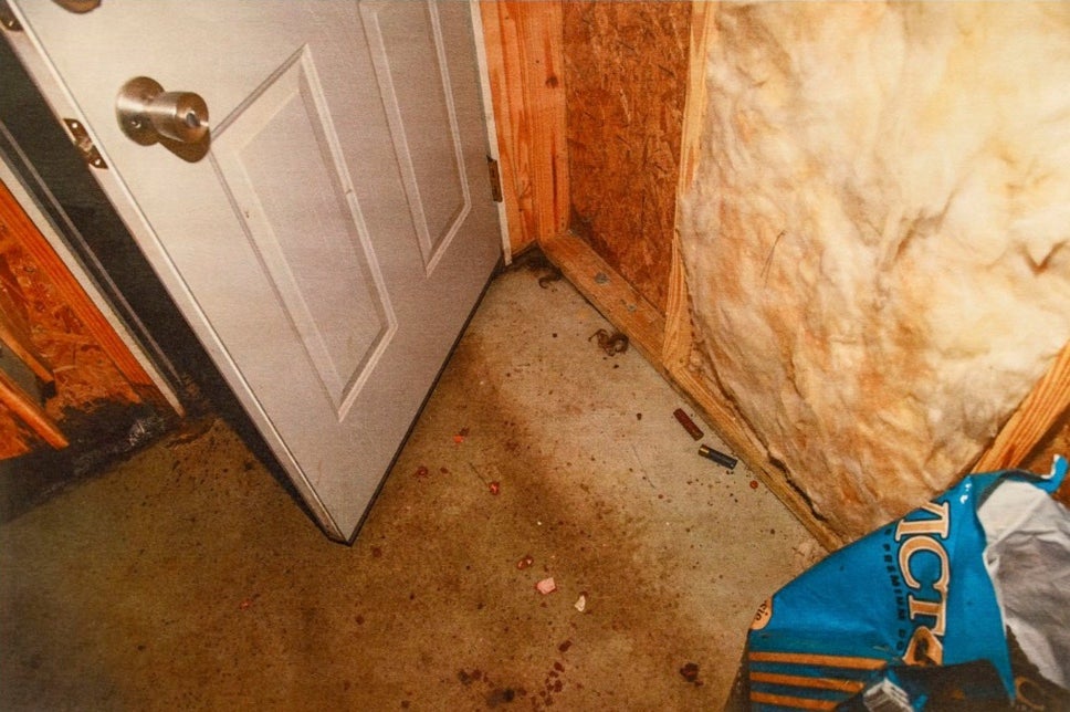 Crime scene photos show shell casings on the floor of the dog feed house