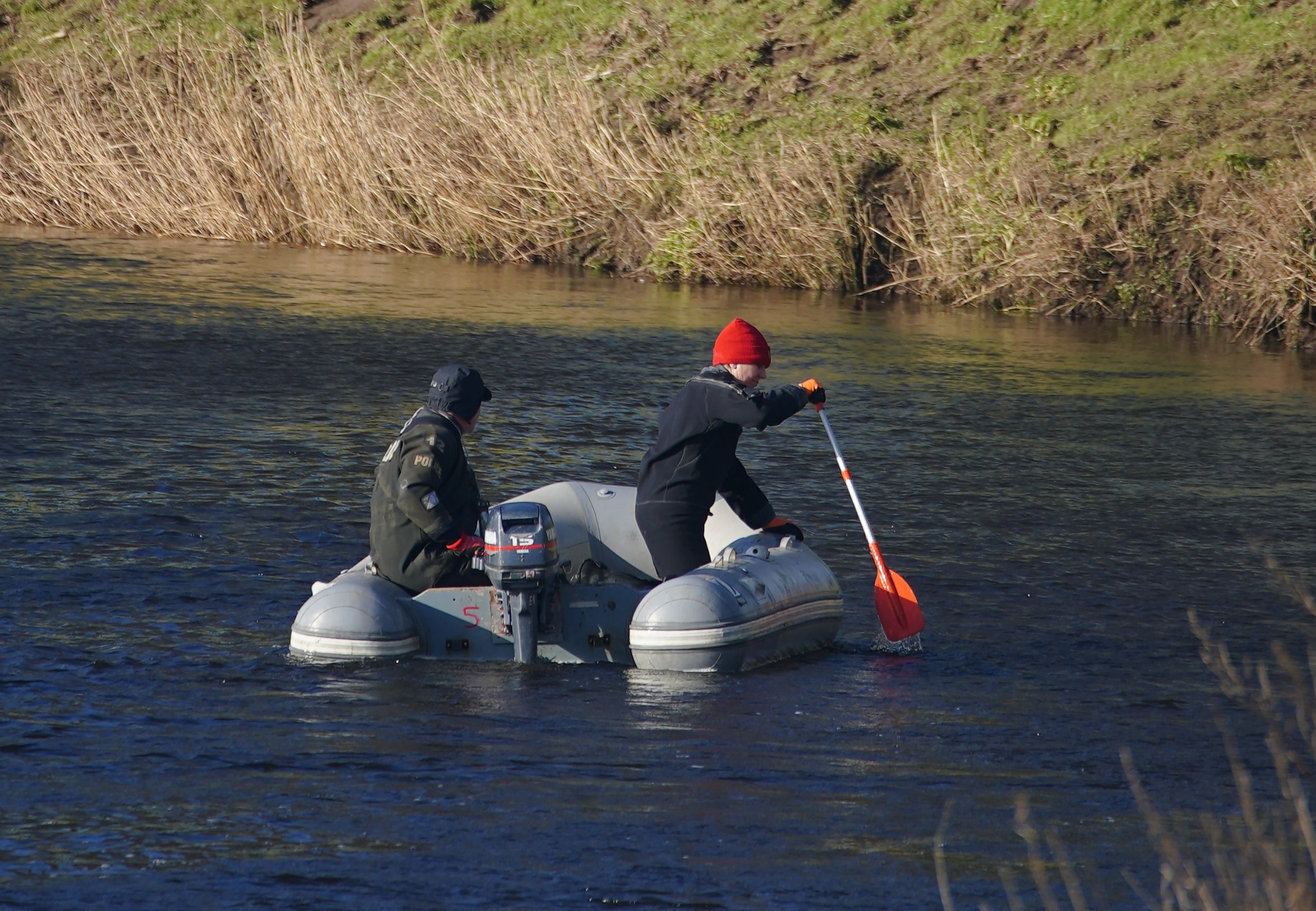 Specialist search officers drive a boat along the River Wyre where Lancashire Police are searching