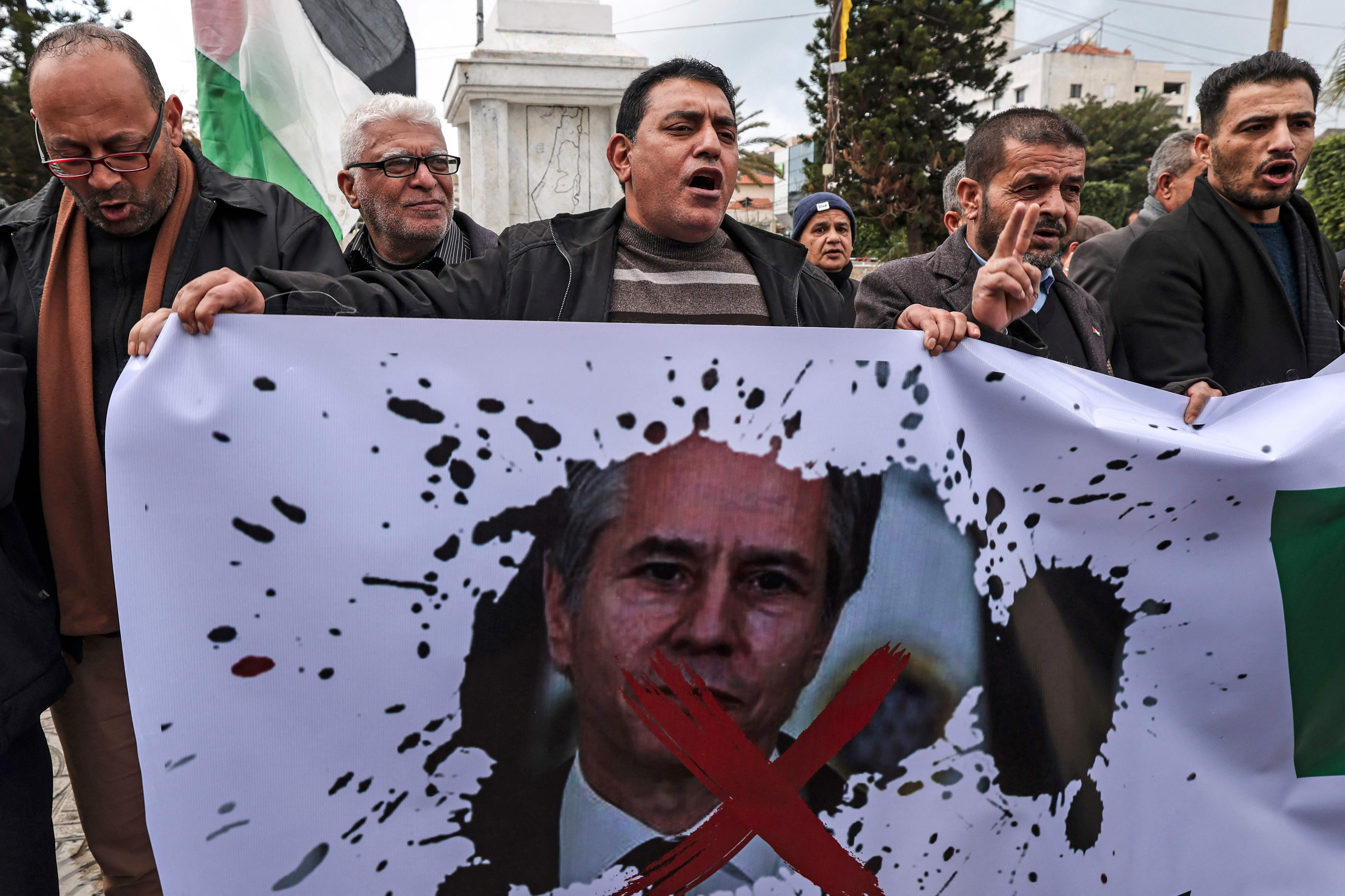 Palestinians hold a banner in Gaza City during Blinken’s visit to the West Bank on Tuesday