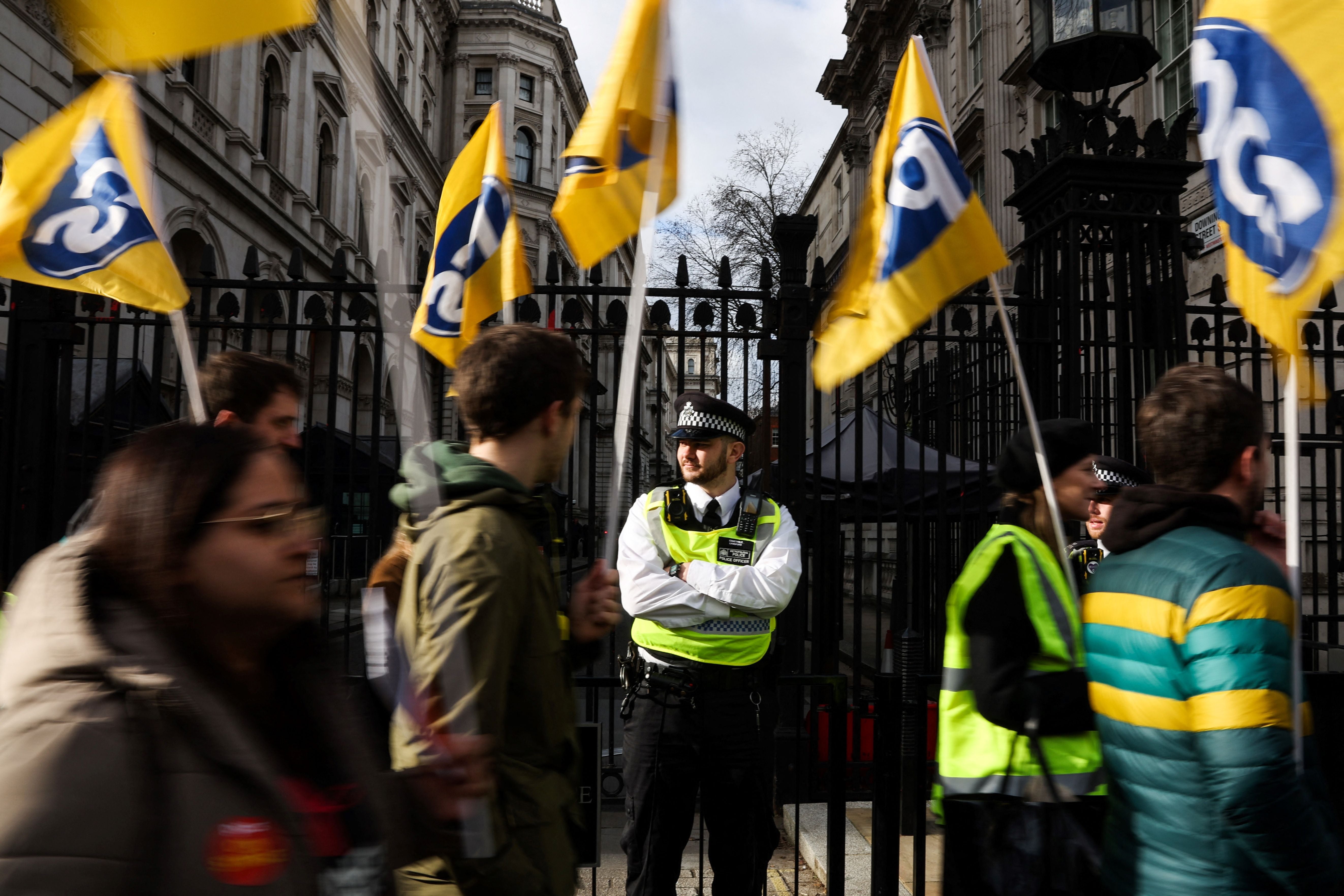 Demonstrators wave flags of the PCS trade union as they march in central London during a demonstration