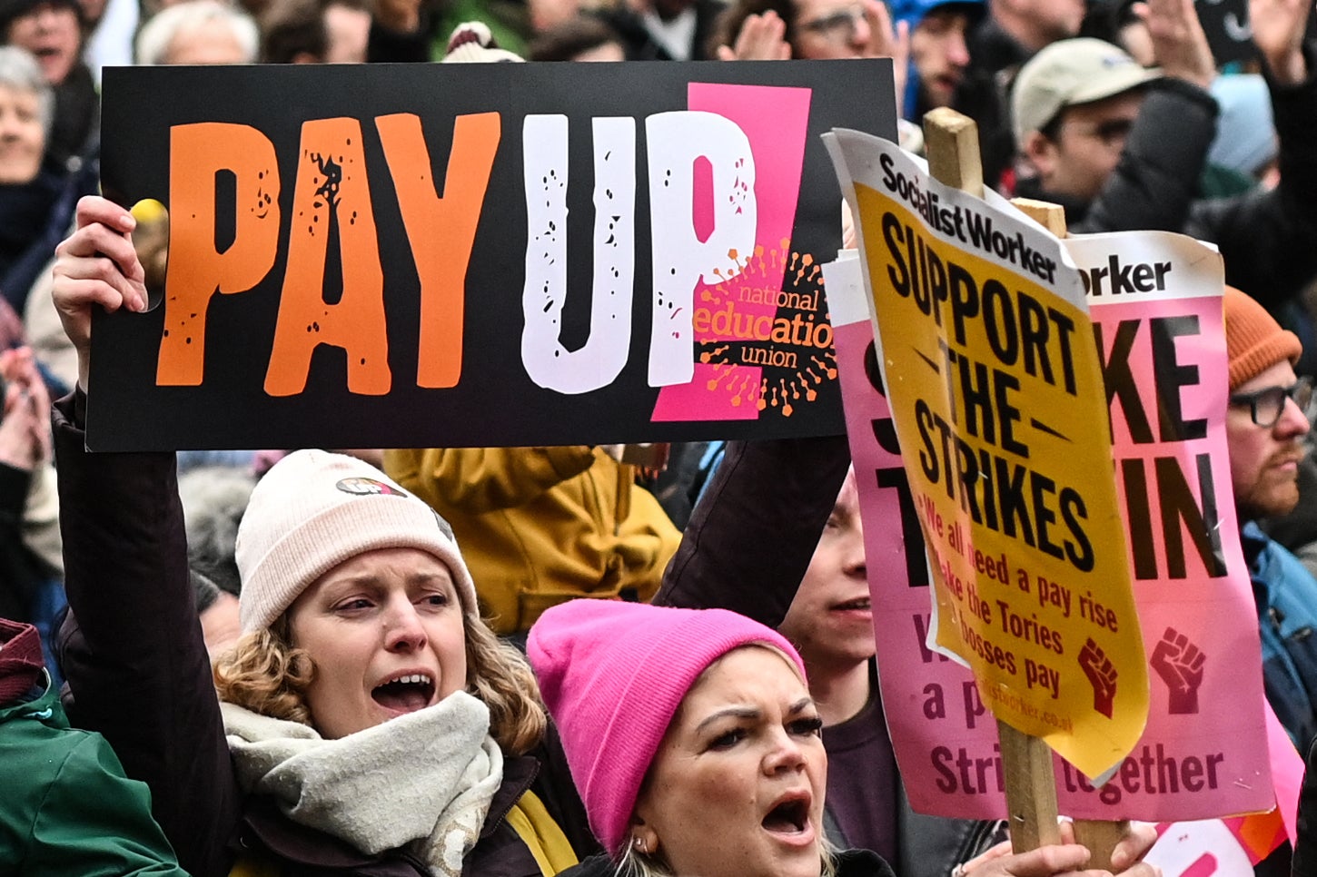 Teacher hold a placard as they shout slogans while taking part in a protest organised NEU and other affiliated trade unions