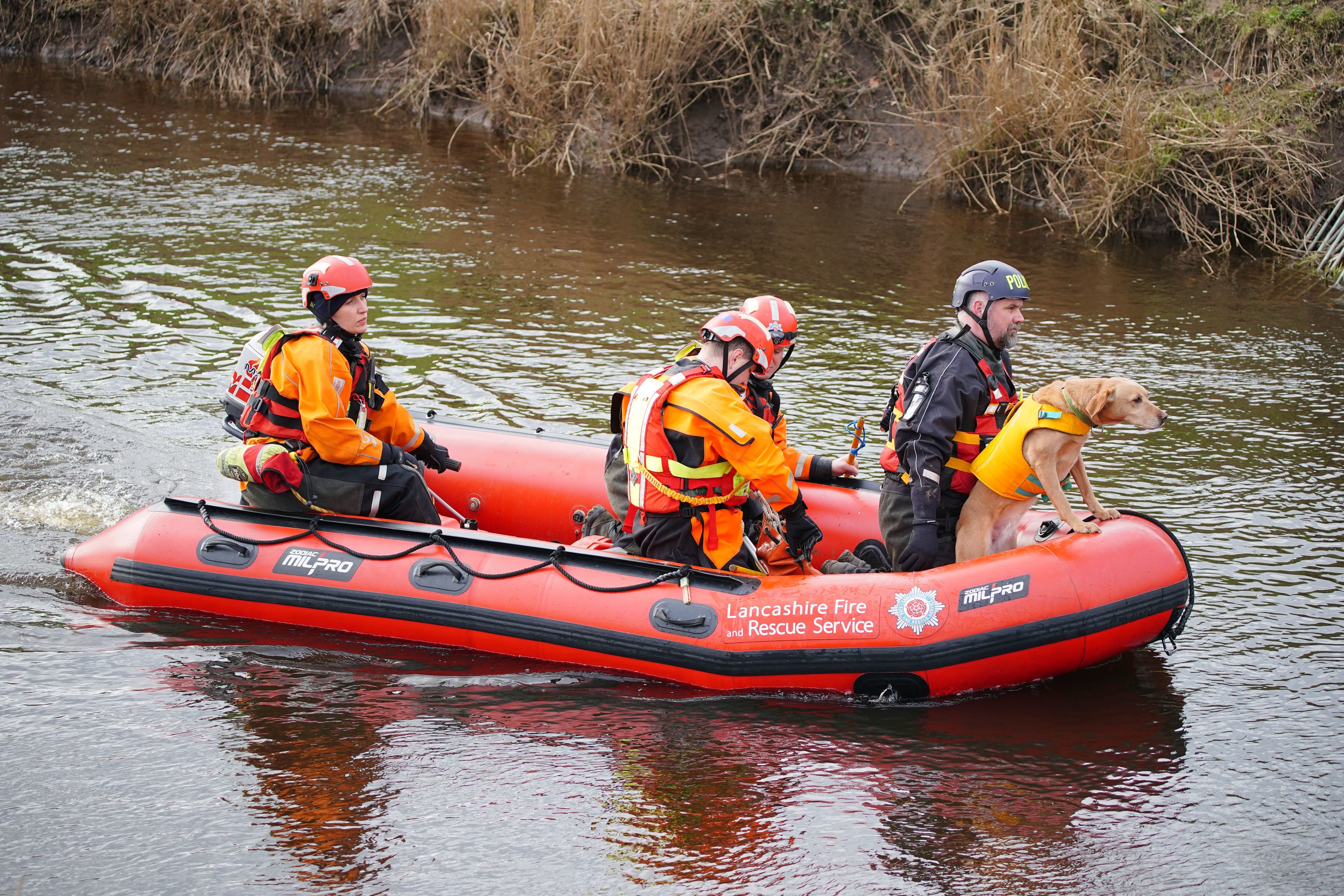 Specialist search teams from Lancashire Fire and Rescue Service and the police, on the River Wyre, in St Michael's on Wyre, Lancashire