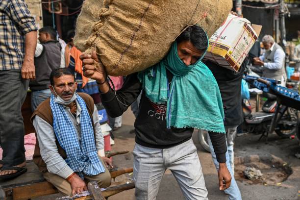 A daily wage worker goes about with his routine work in New Delhi