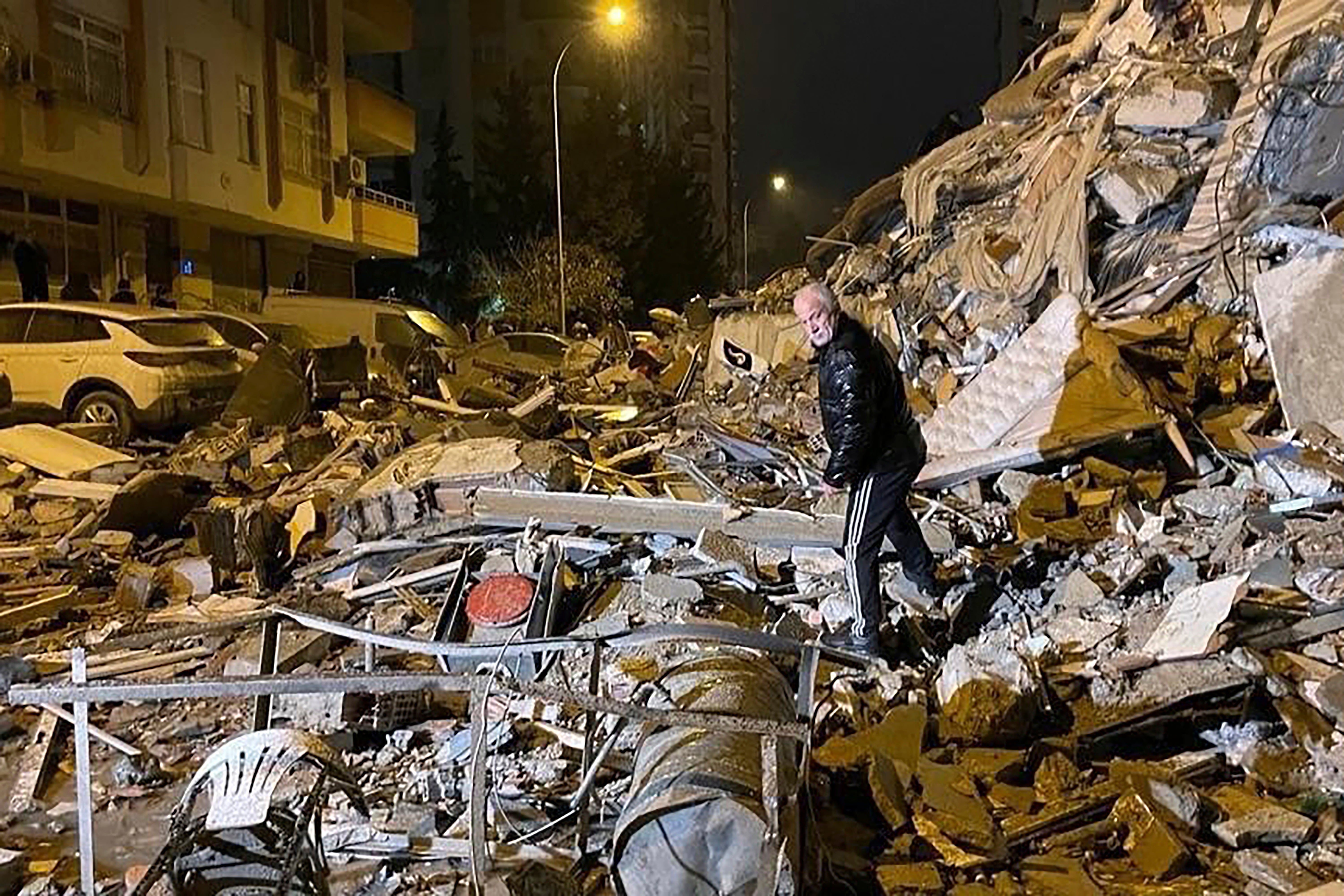 A man searches collapsed buildings in Diyarbakir, southern Turkey