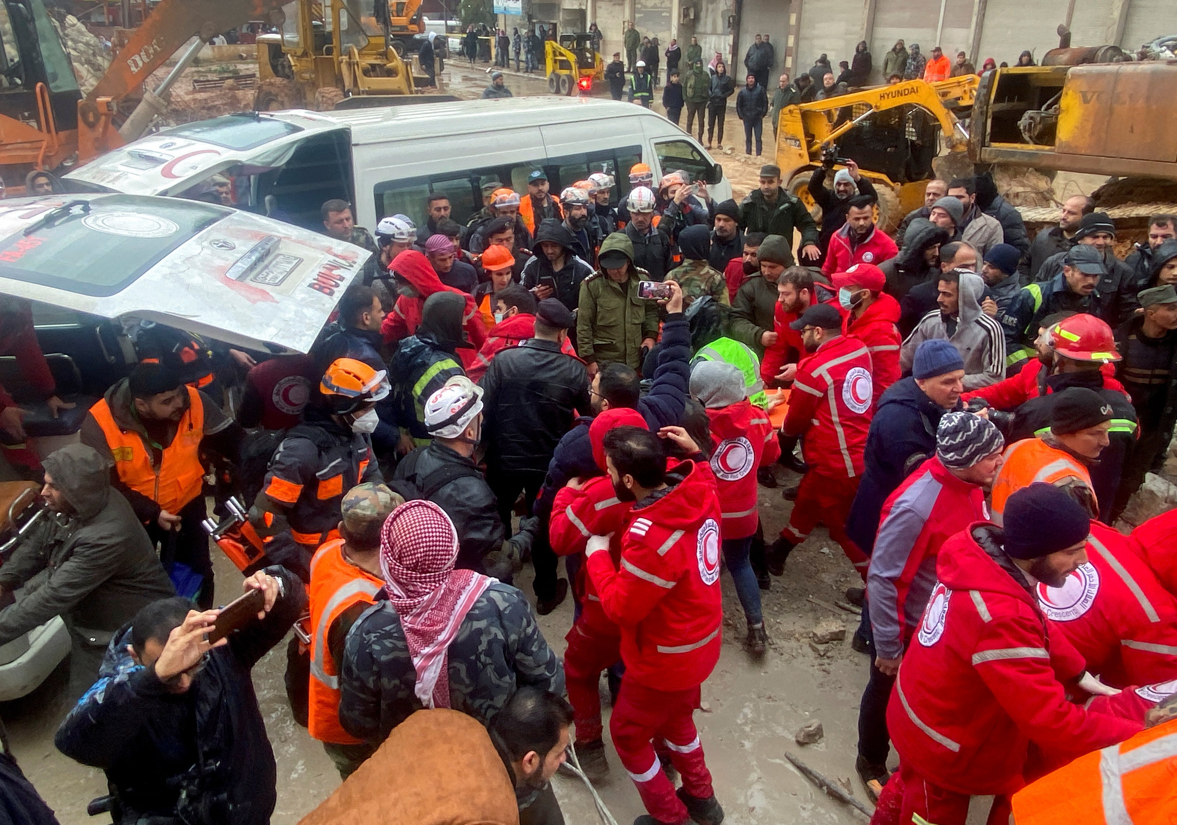 Rescuers work near the site of a collapsed building, following an earthquake, in Hama, Syria