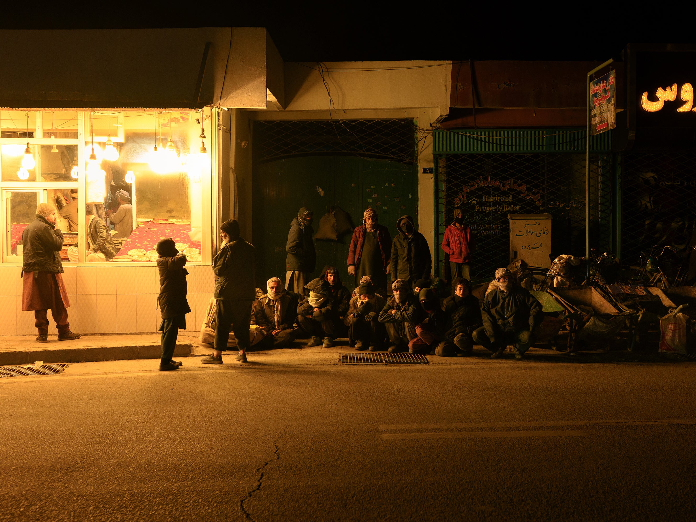 Workers unable to find employment park their wheelbarrows next to a bakery in central Kabul